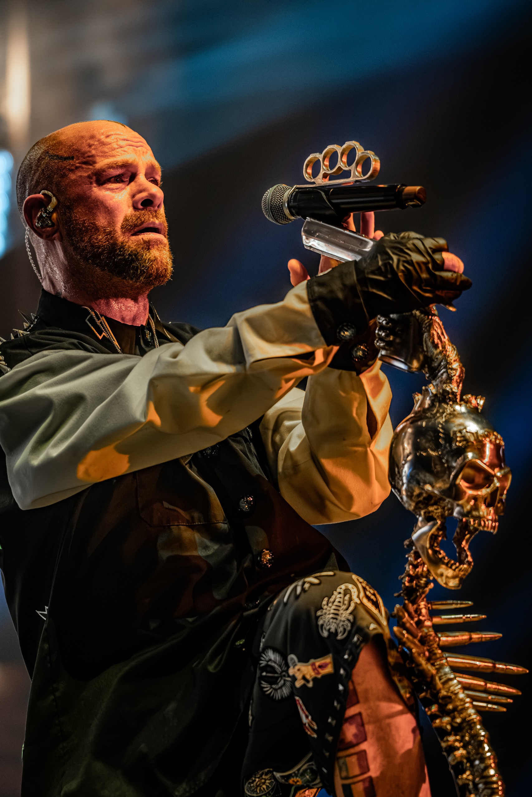 Ivan Moody singing beside his skeletal microphone stand. Five Finger Death Punch at Coastal Credit Union Music Park, Raleigh, October 14, 2026.