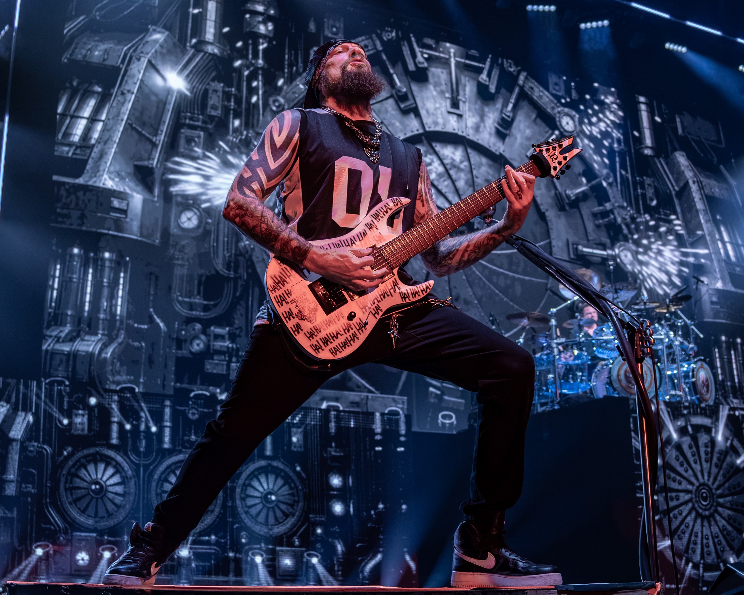 Five Finger Death Punch guitarist playing in front of the drum riser. Five Finger Death Punch at Coastal Credit Union Music Park, Raleigh, October 14, 2026.