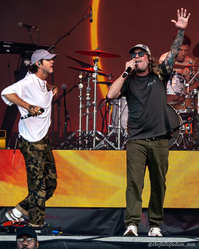 Dirty Heads vocalists performing together with one hand raised.