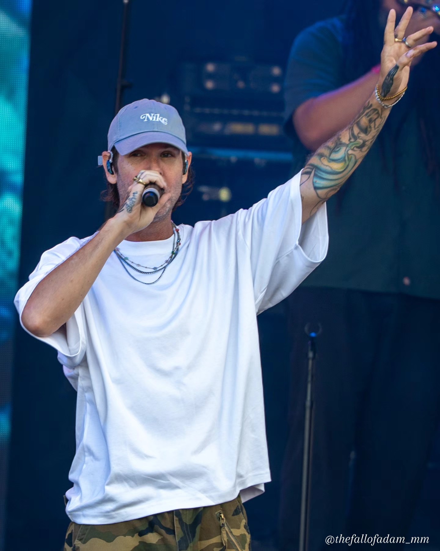 Dirty Heads vocalist raising his hand at the microphone.