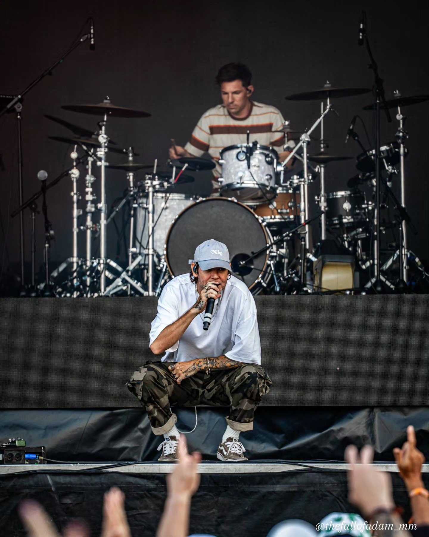 Dirty Heads vocalist crouching at the front of the stage.