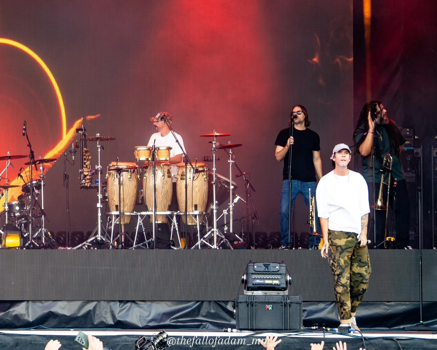 Wide view of Dirty Heads with percussion instruments and stage screens.