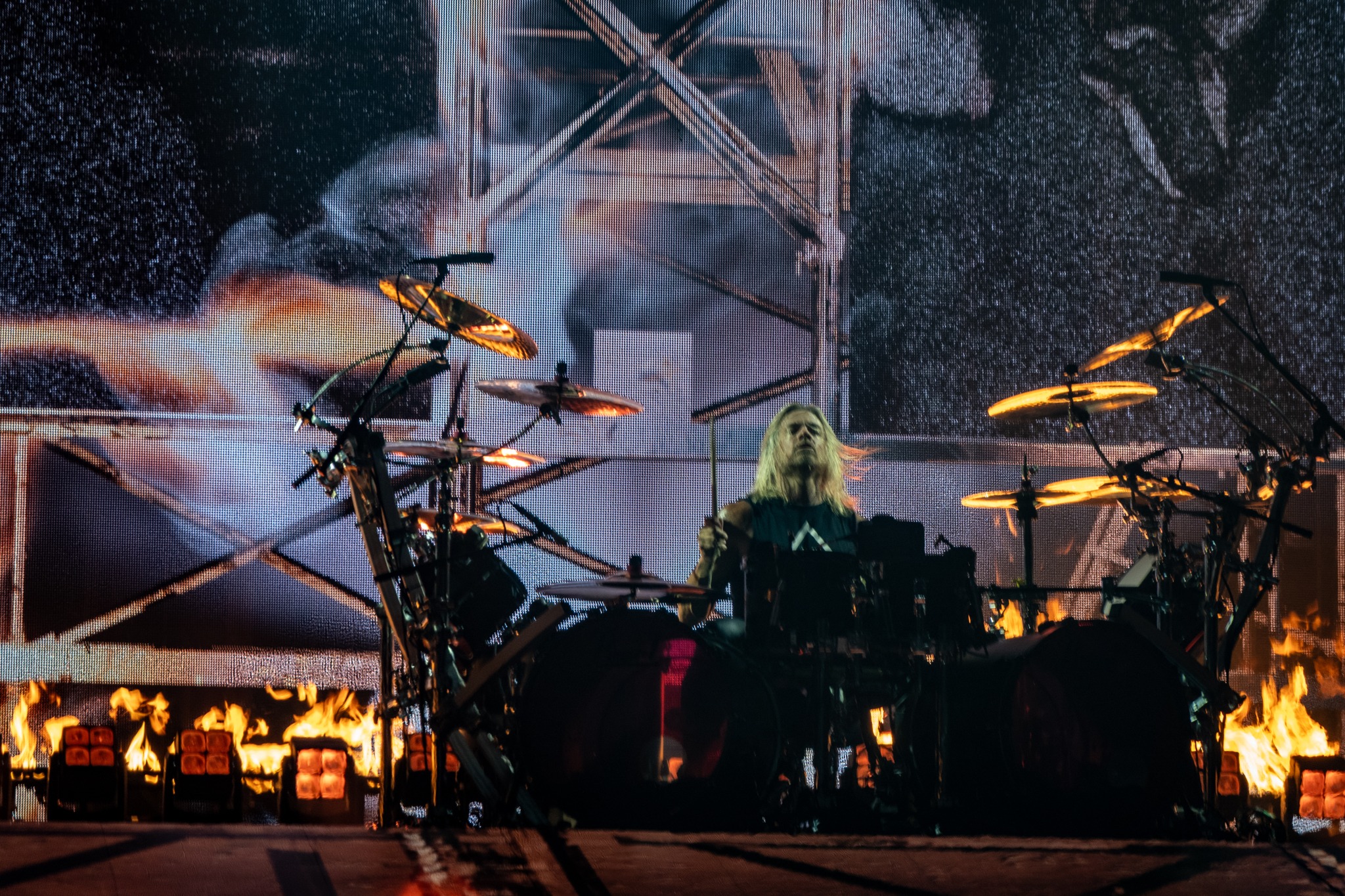 Evanescence drummer at the kit beneath stage screens.