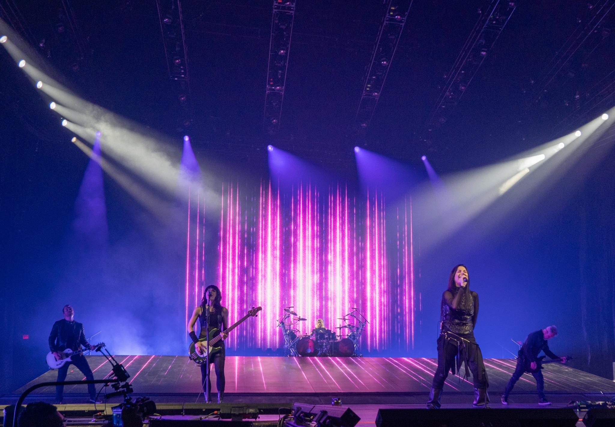 Wide view of Evanescence beneath purple stage lighting.
