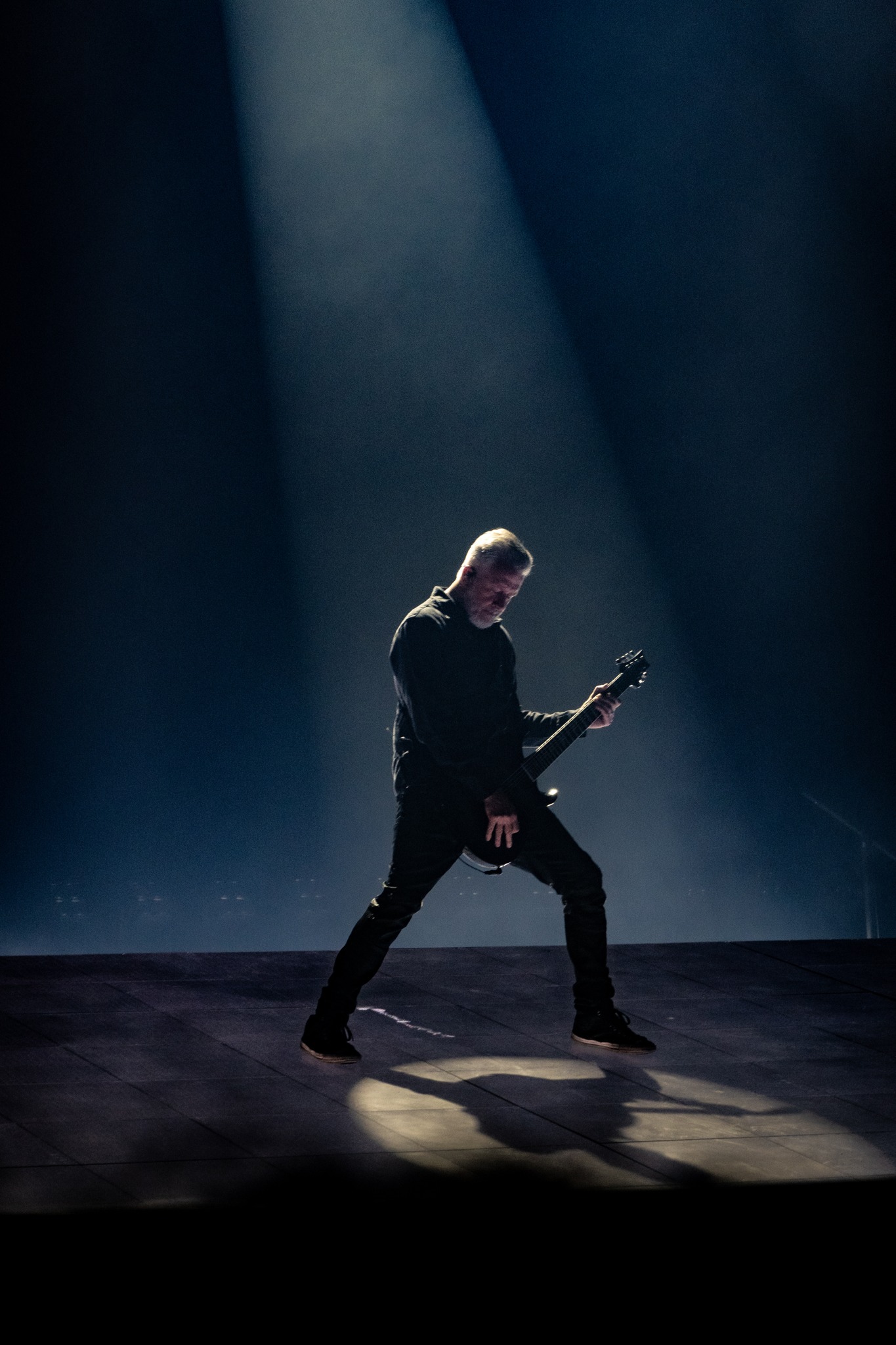 Evanescence musician silhouetted against a narrow beam of light.