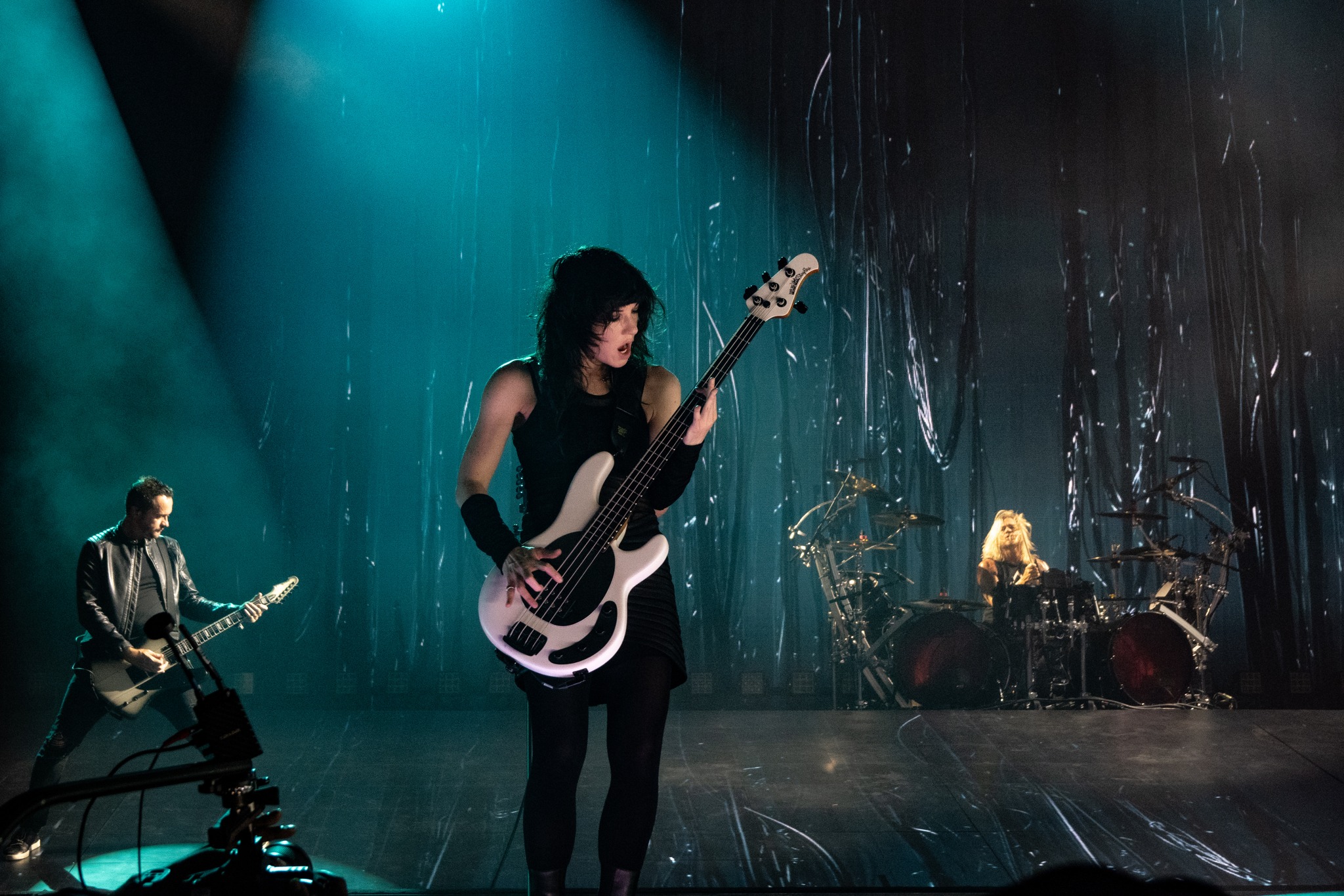 Evanescence guitarist performing under teal light.