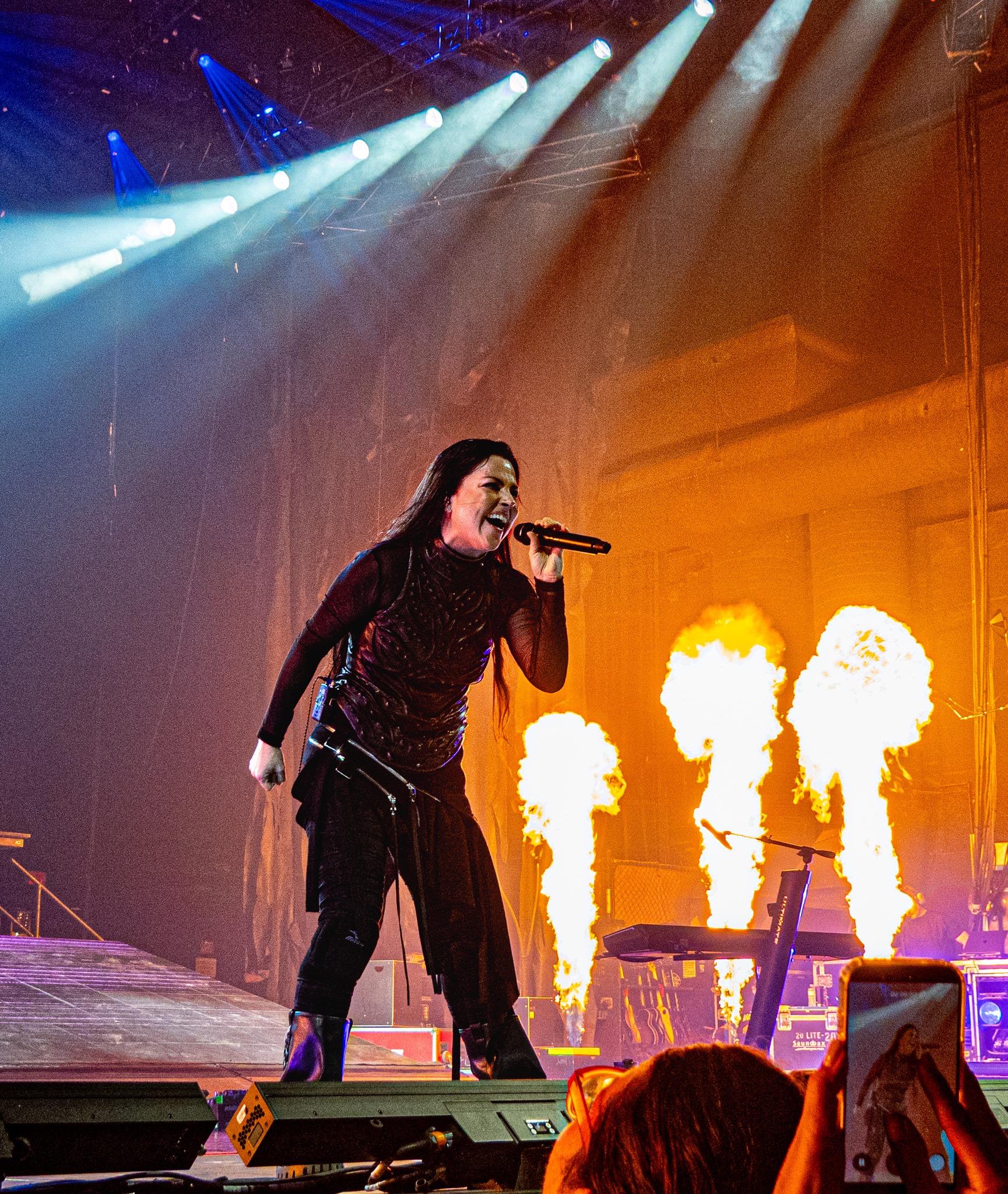Amy Lee performing beside columns of flame.
