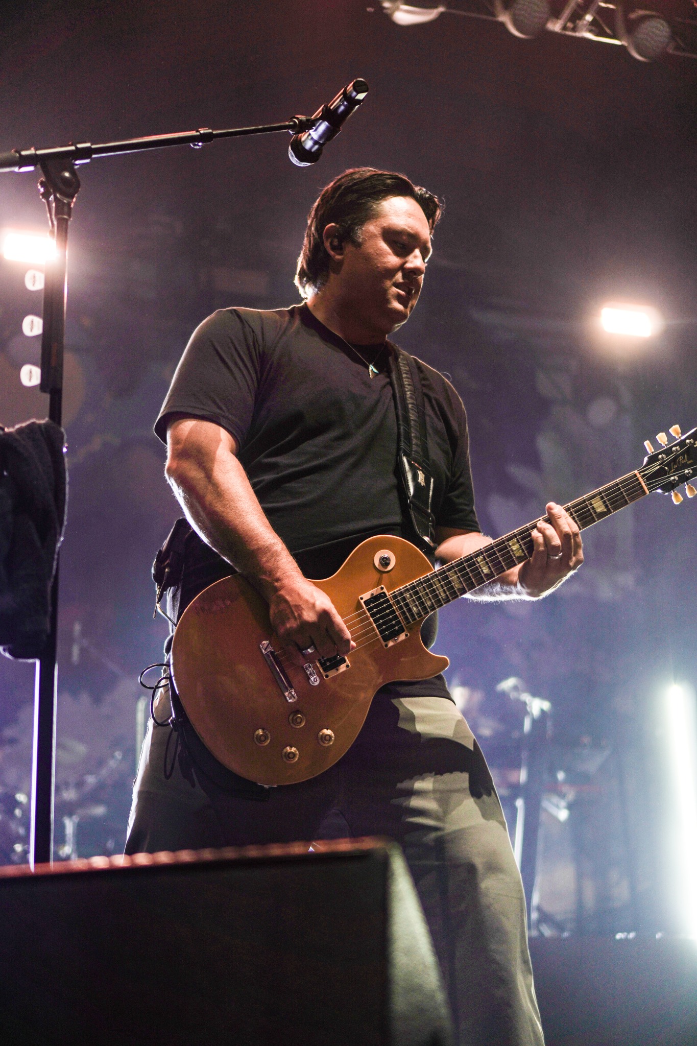 Iration vocalist playing guitar at the microphone.