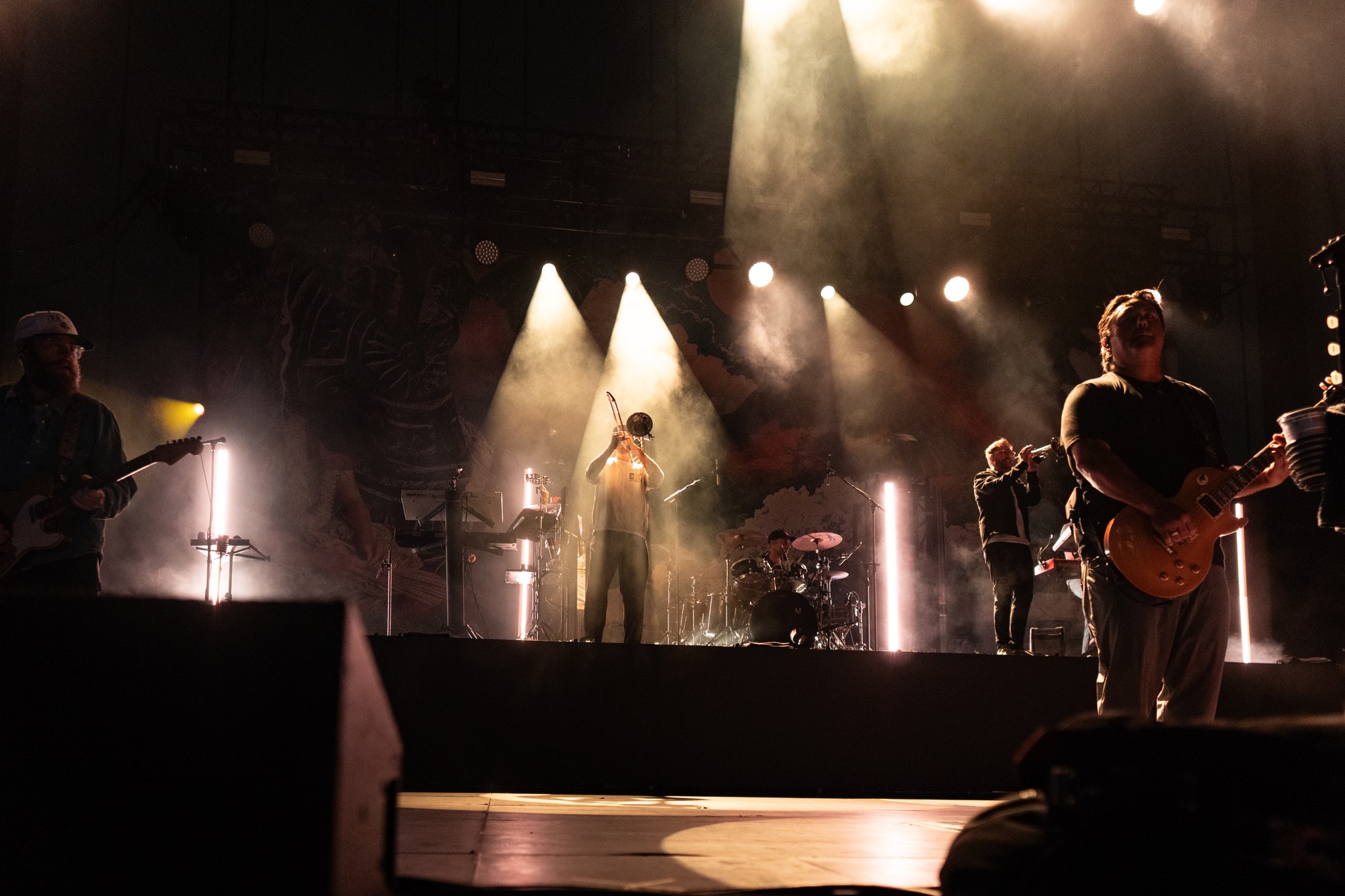 Iration band members performing amid warm stage haze.