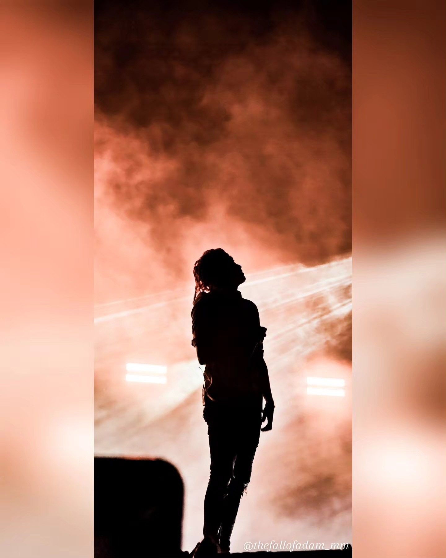 Lorna Shore vocalist silhouetted against orange stage haze.