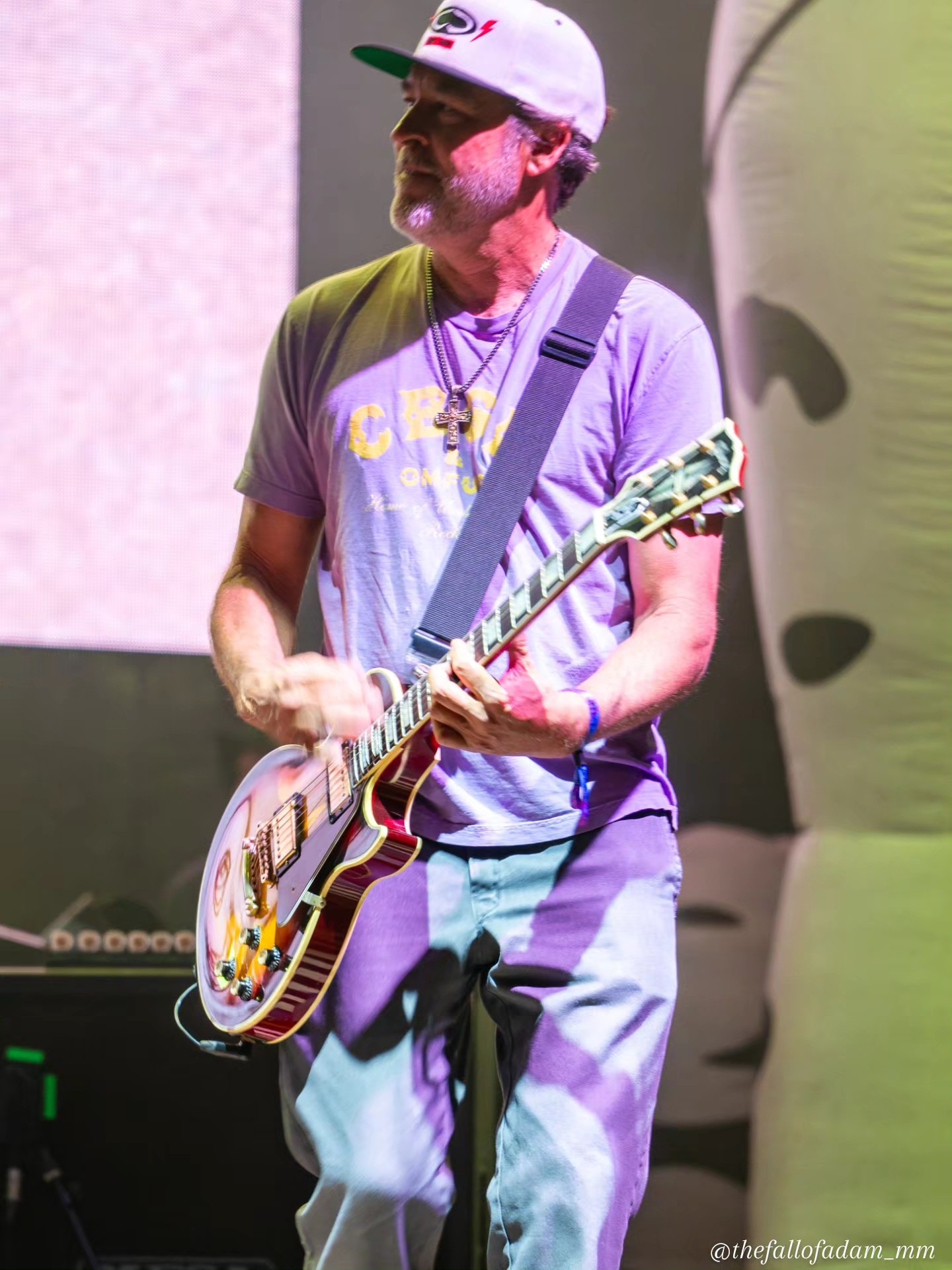 Sublime guitarist playing beneath stage light.