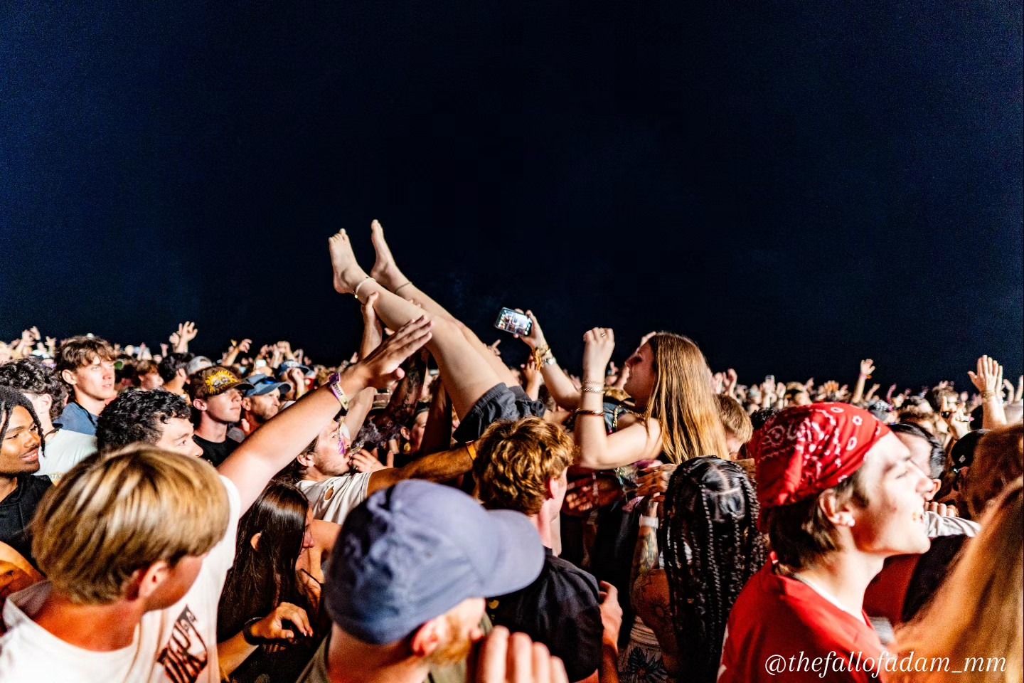 A crowdsurfer supported by fans during Sublime.