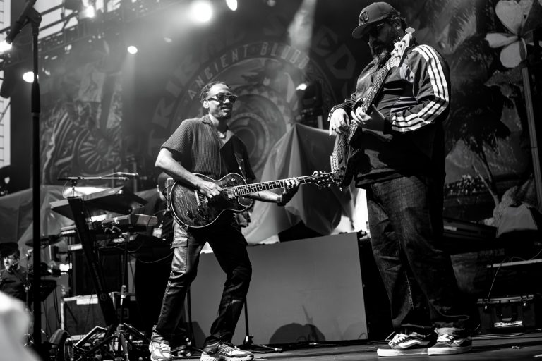 Black and white photograph of two Tribal Seeds guitarists playing together.