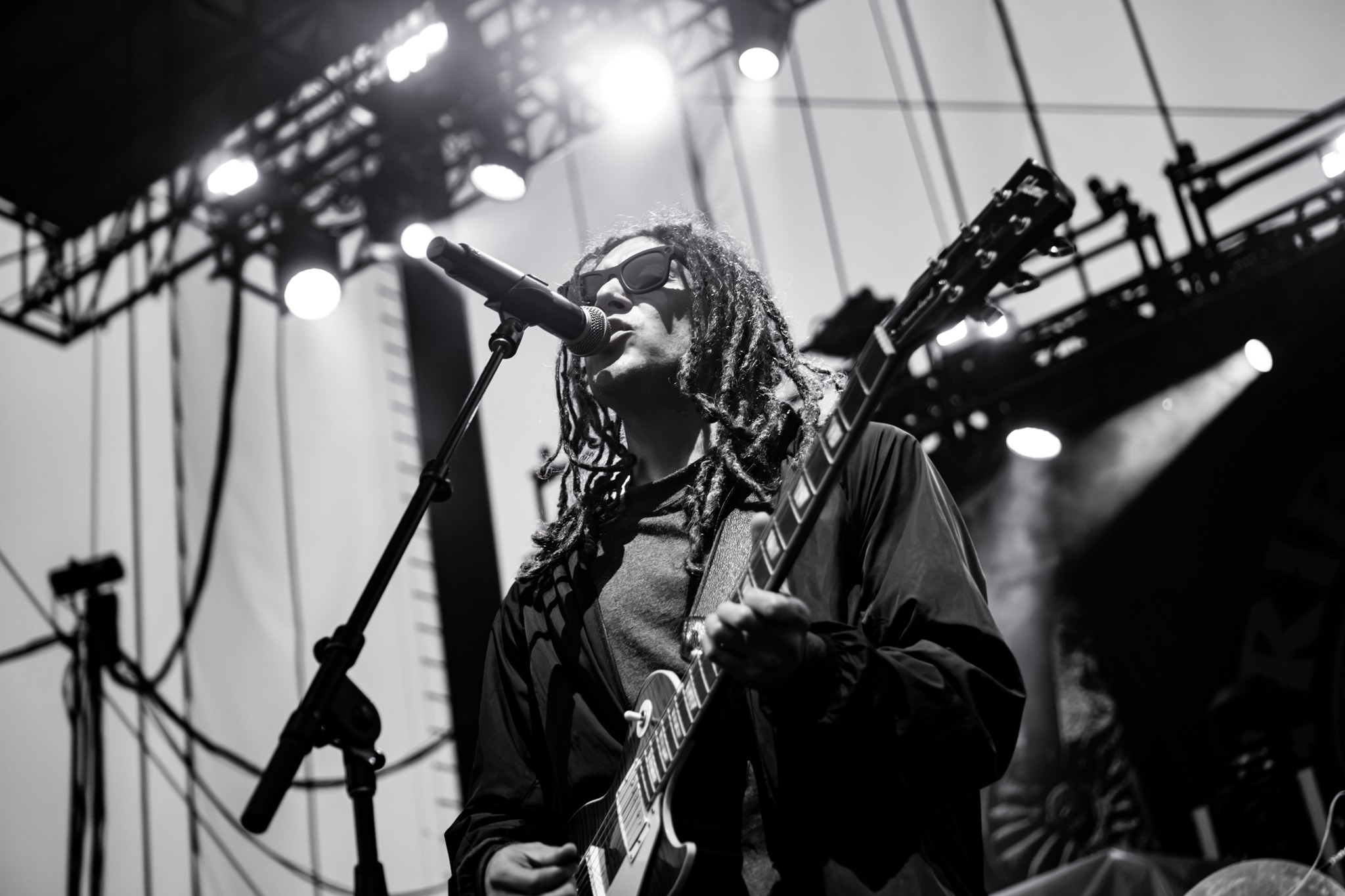 Black and white portrait of a Tribal Seeds guitarist at the microphone.