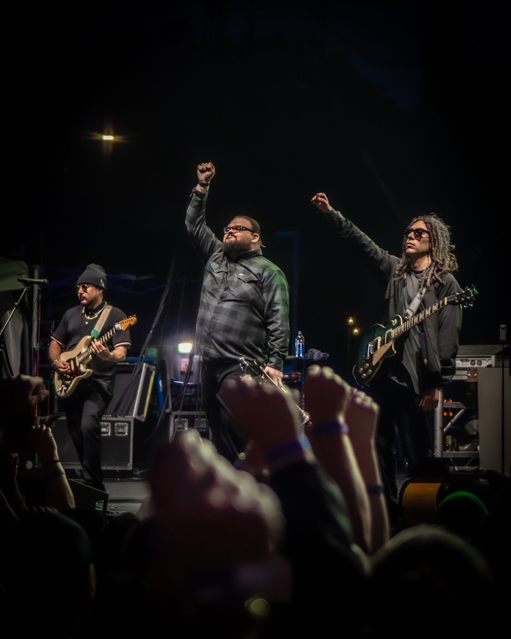 Tribal Seeds musicians raising their hands toward the crowd.