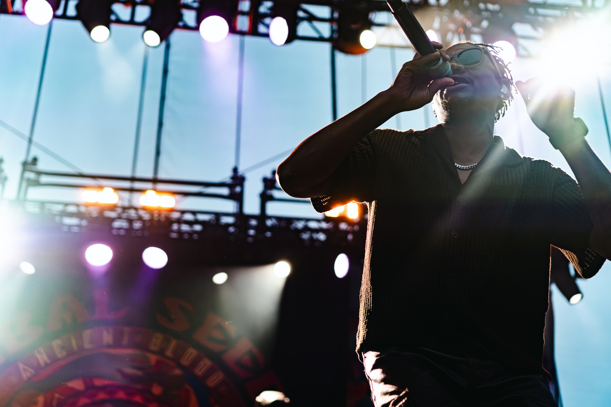 Tribal Seeds vocalist silhouetted against bright stage light.