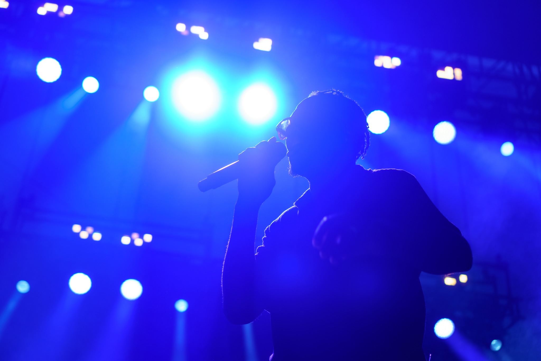 Tribal Seeds vocalist singing under blue light.