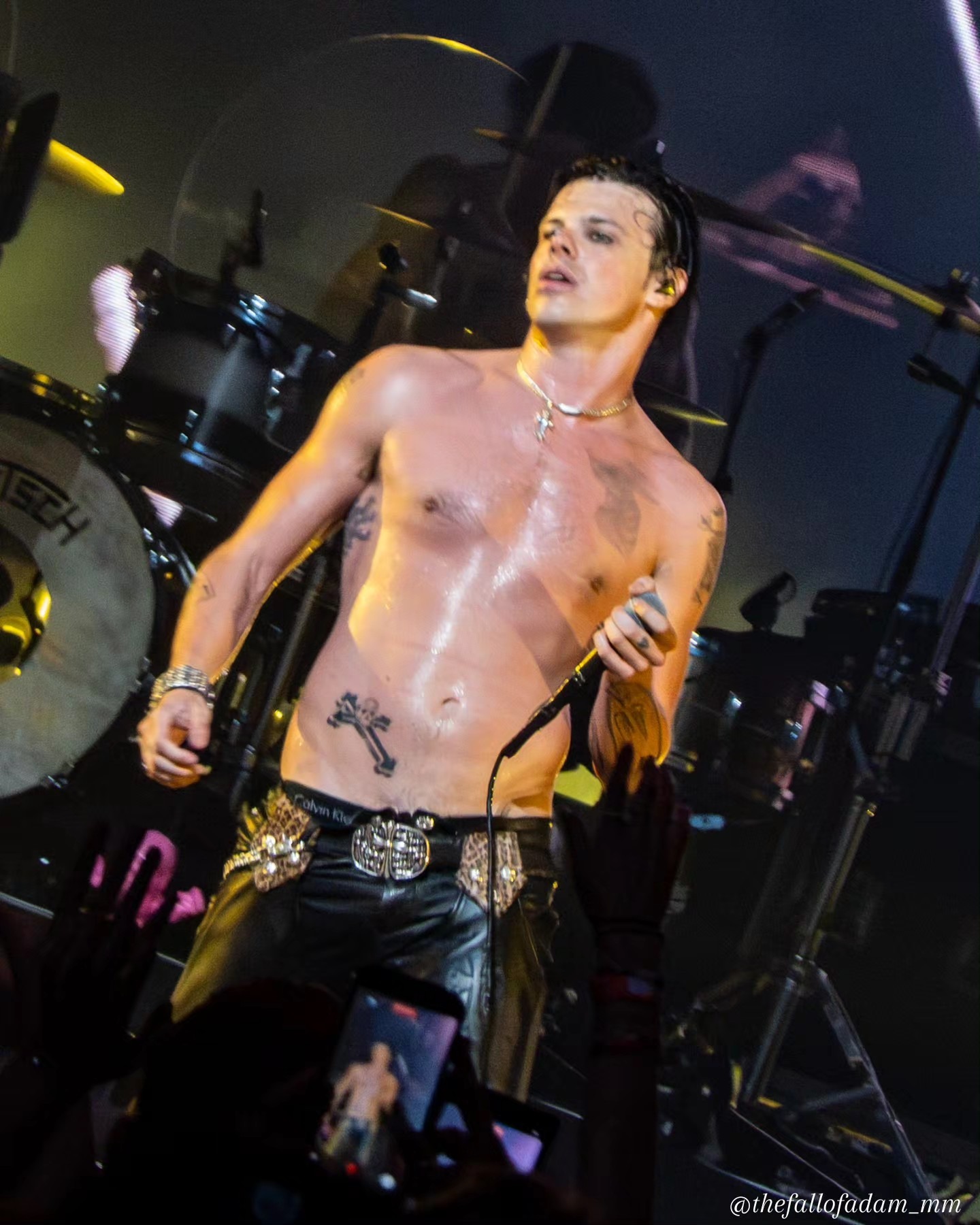 Yungblud standing beside the microphone stand onstage.