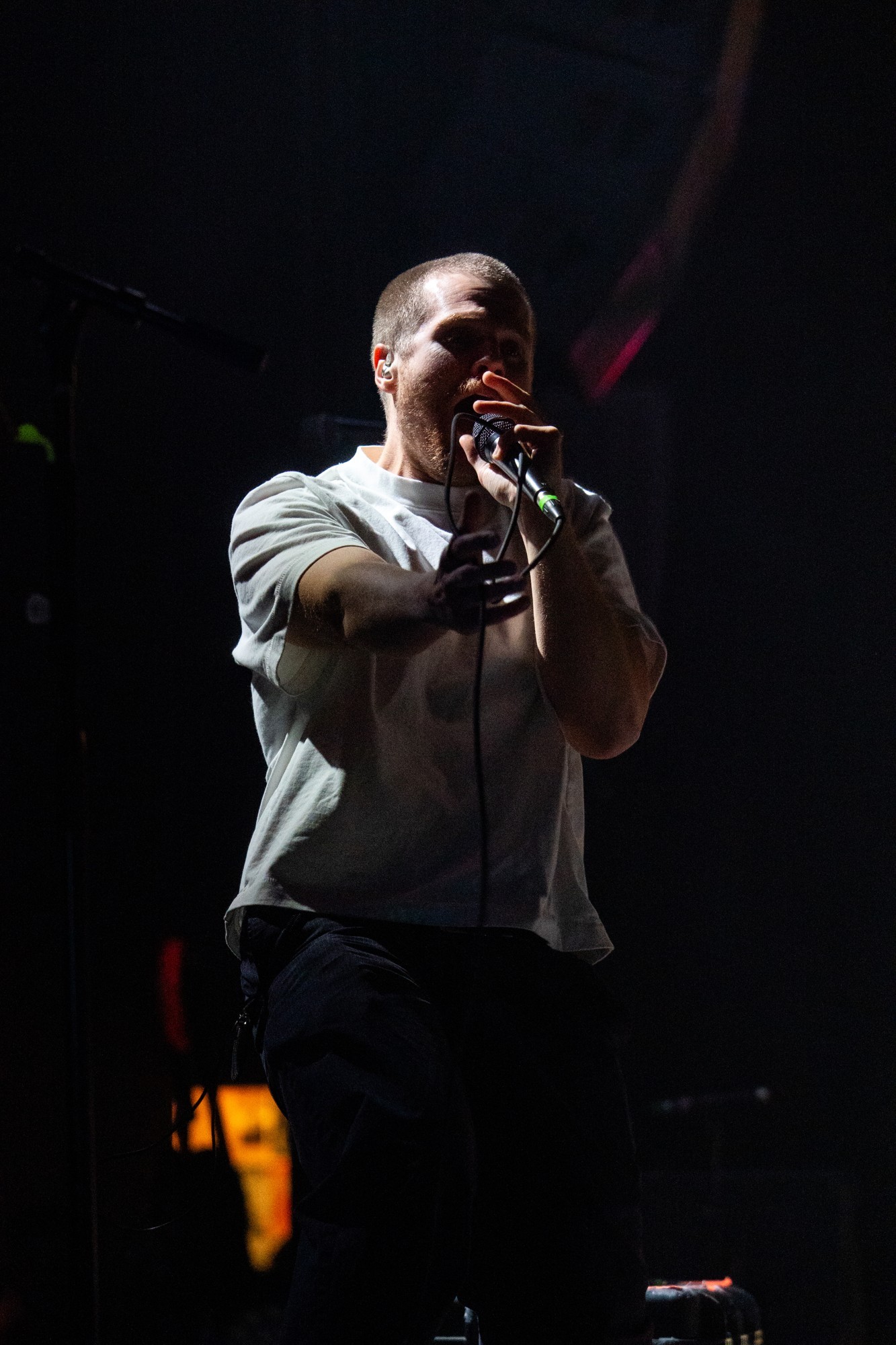 Dead Poet Society vocalist singing against a dark stage.