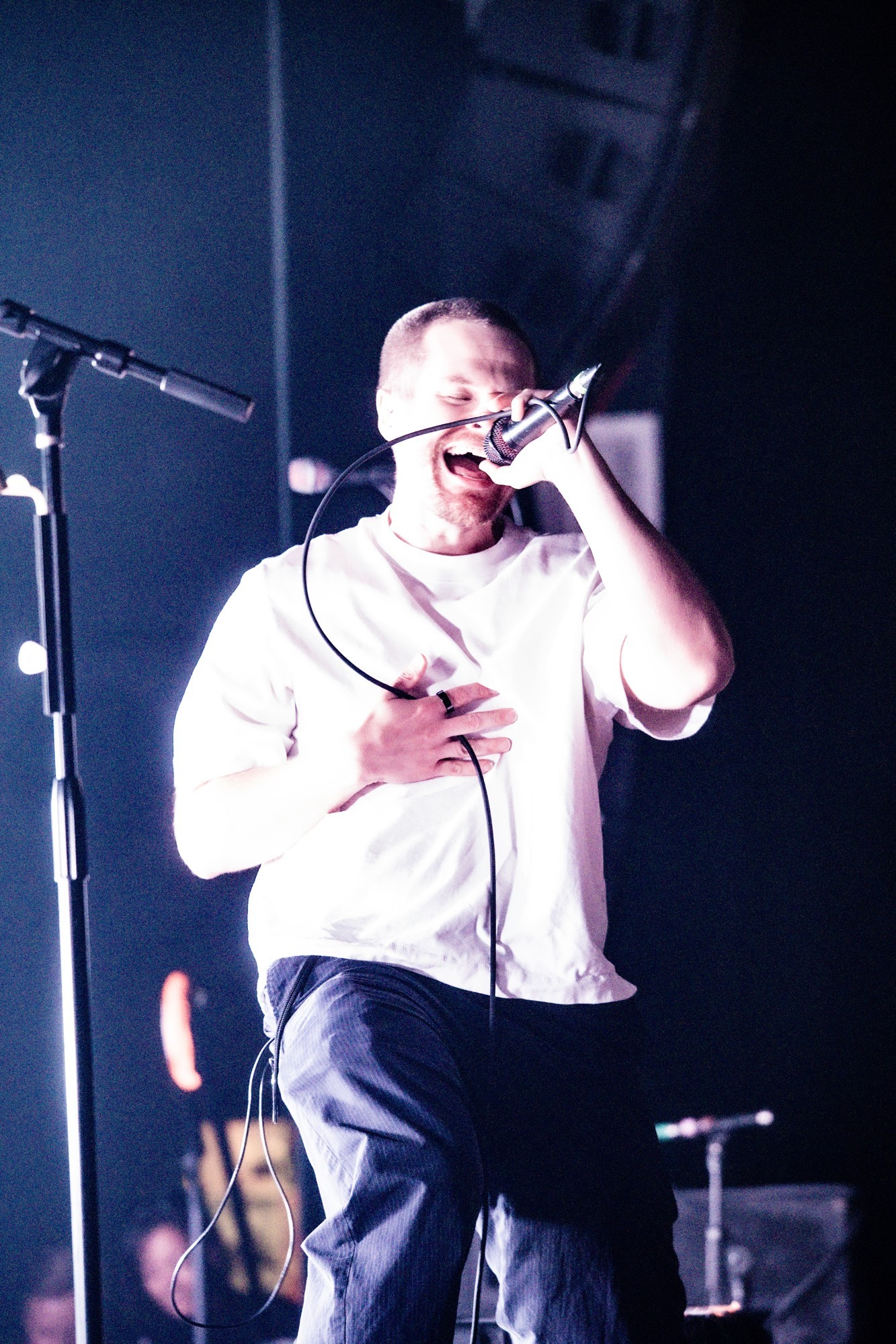Dead Poet Society vocalist singing into the microphone.