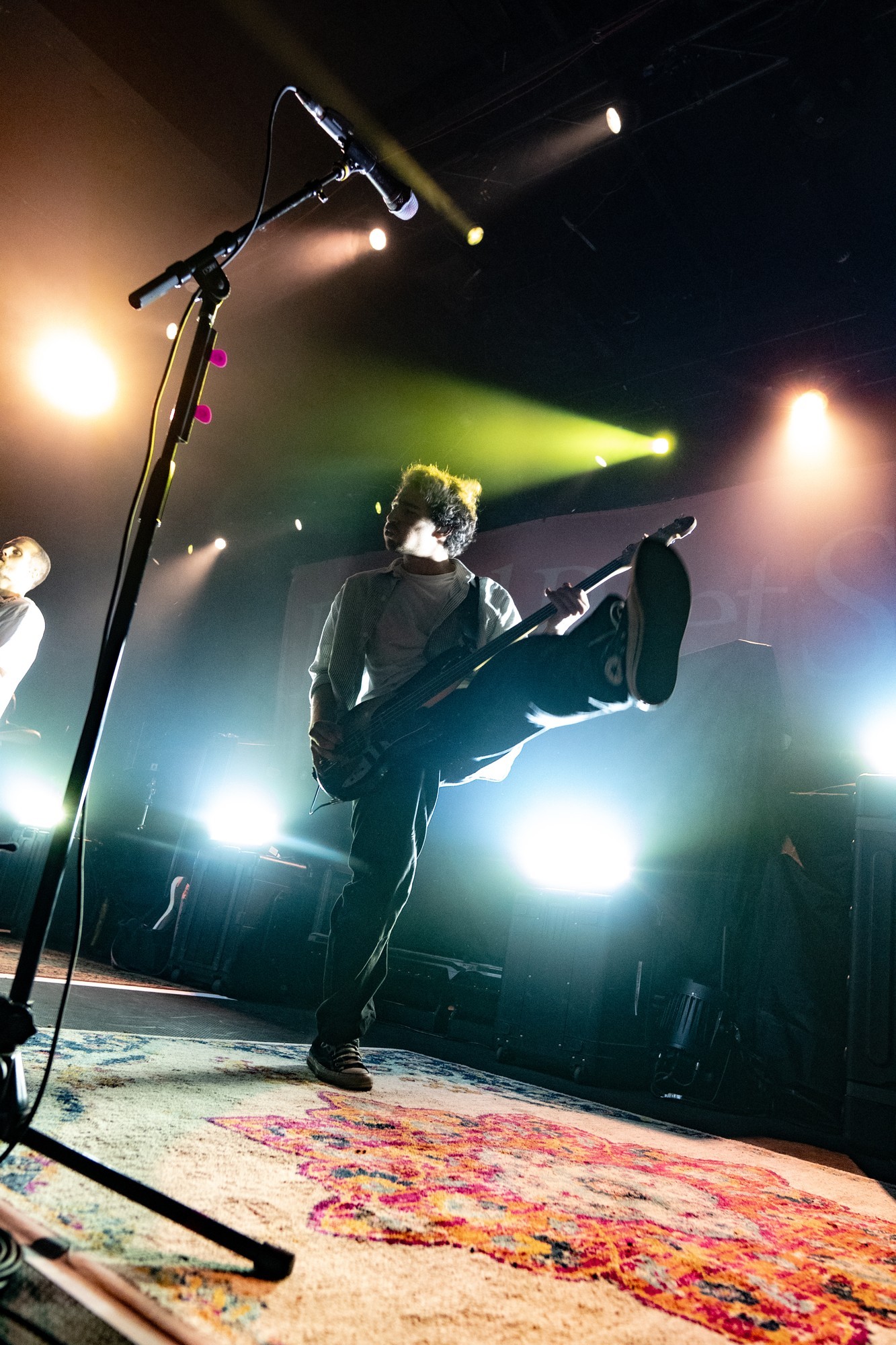 Dead Poet Society guitarist silhouetted against stage lights.