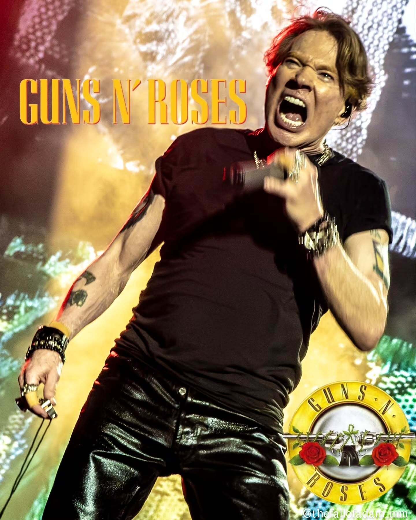 Axl Rose singing beneath warm gold stage lights.