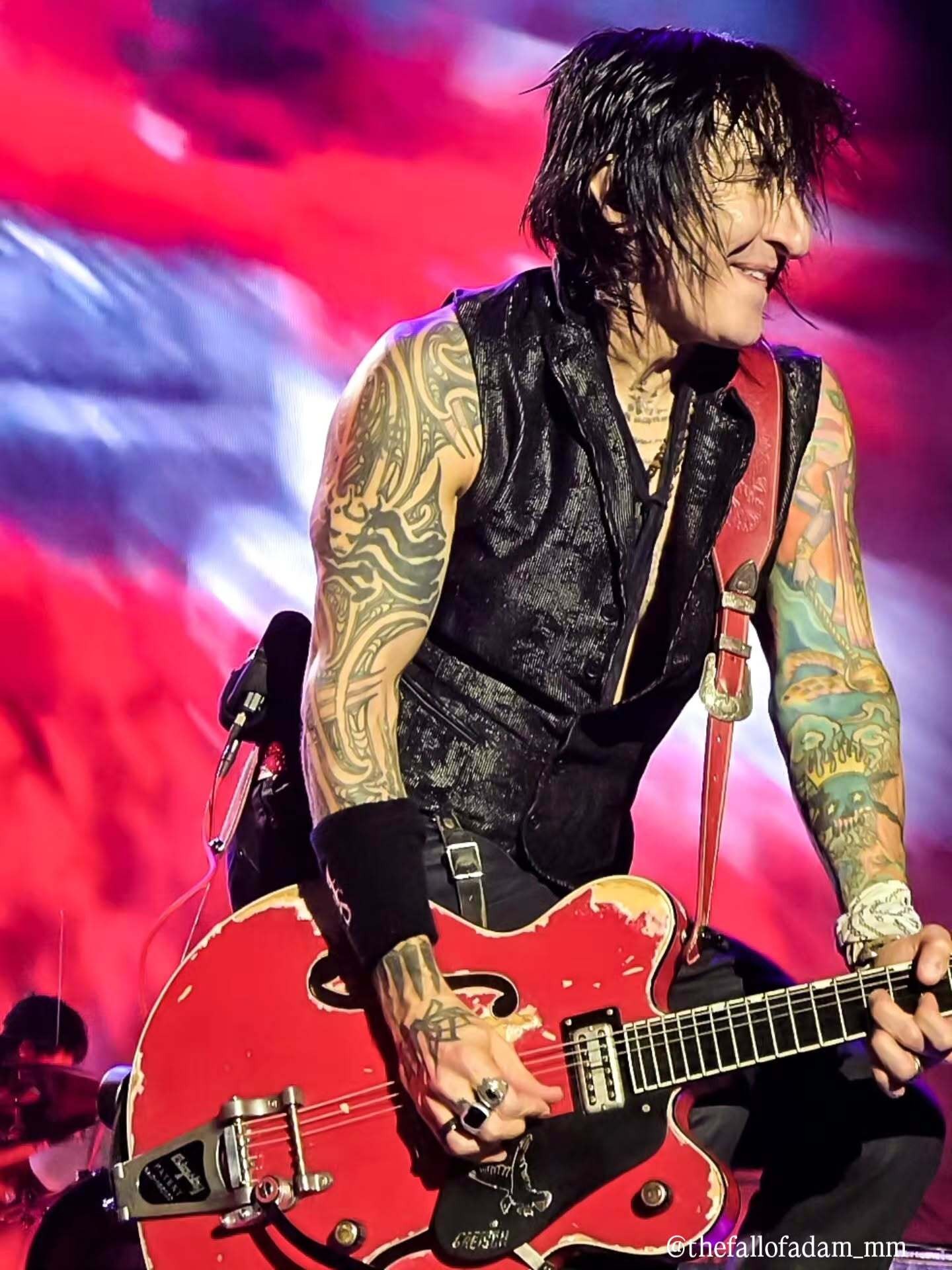Richard Fortus performing with a red guitar.
