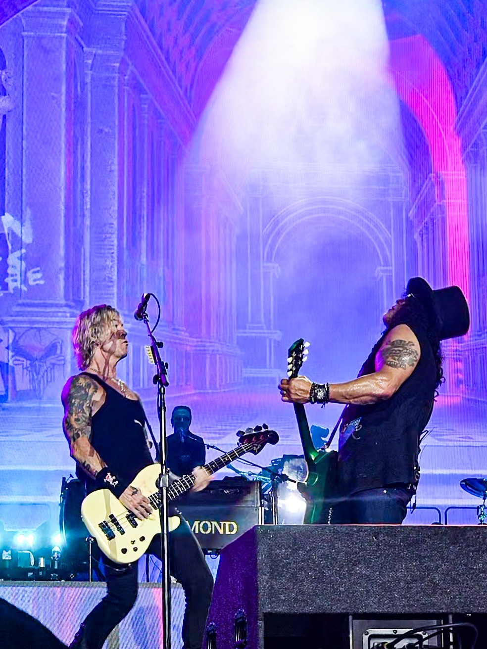 Guns N’ Roses musicians sharing a moment onstage.