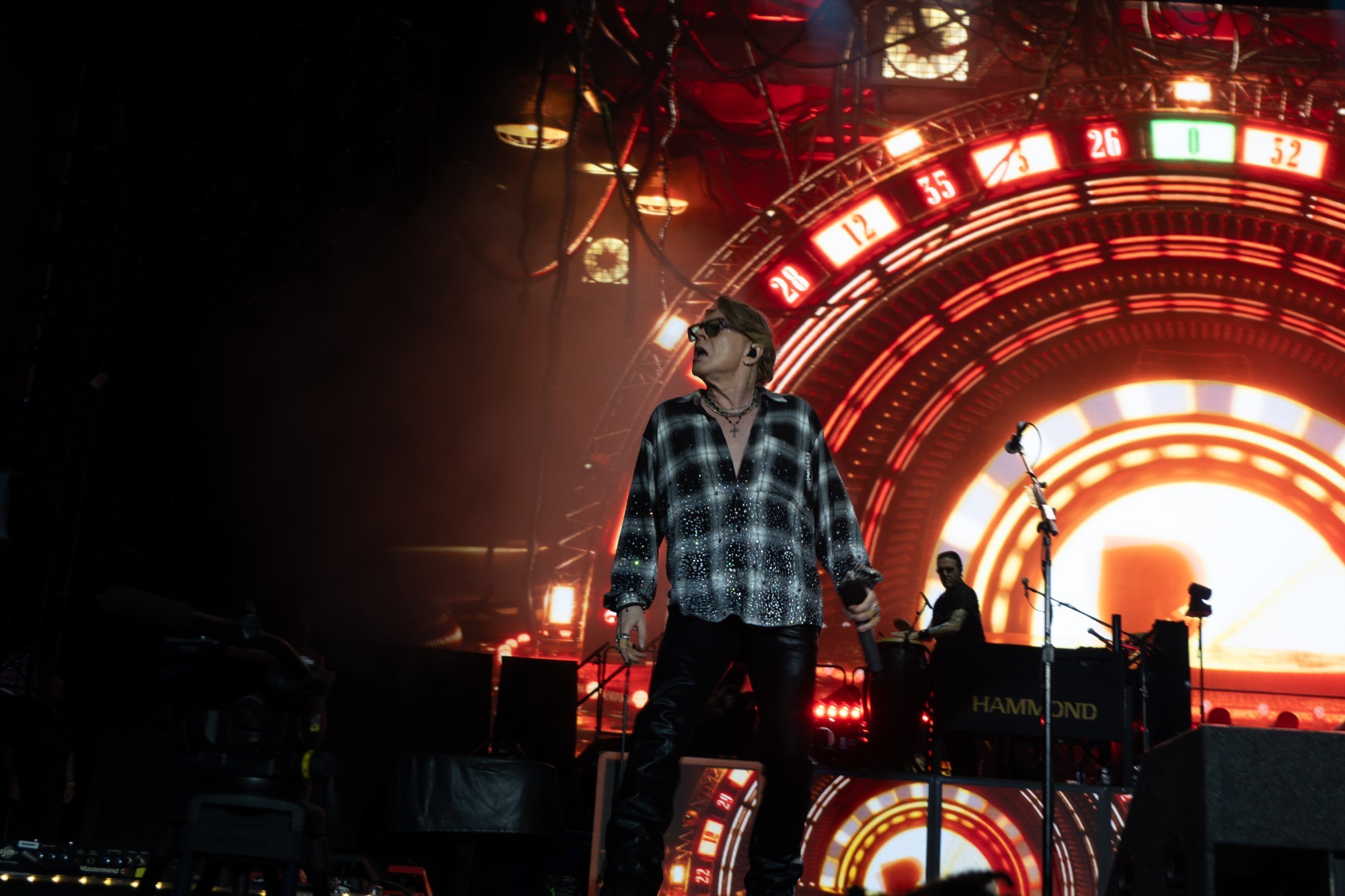 Wide view of Axl Rose and the illuminated stage backdrop.
