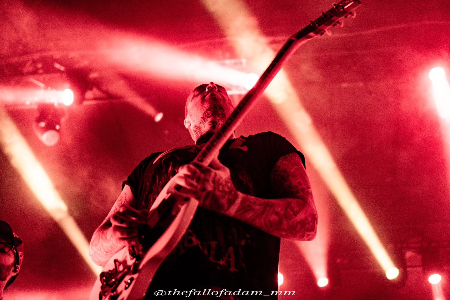 Highly Suspect guitarist playing beneath red spotlights.