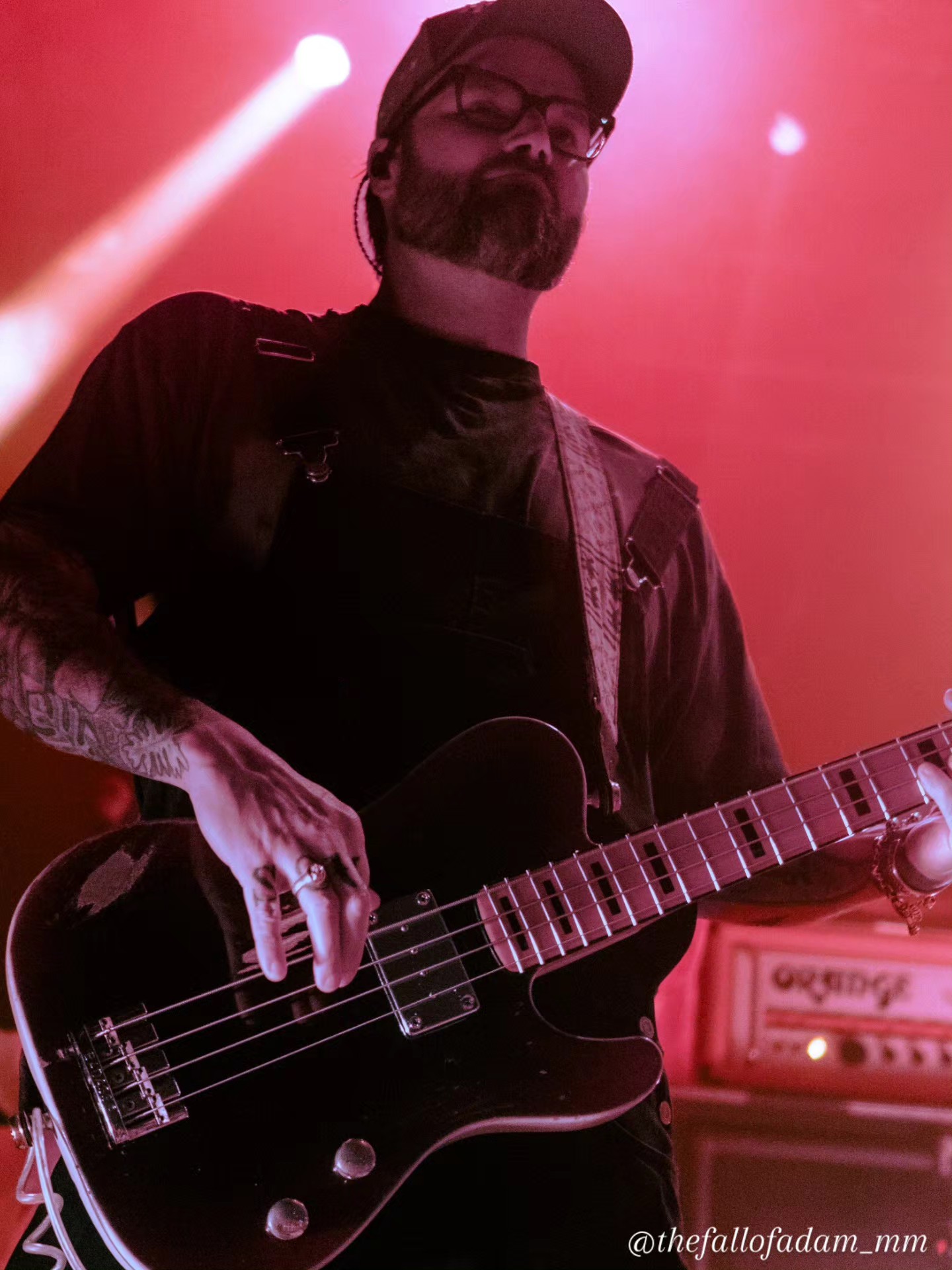 Highly Suspect bassist performing under pink and red light.