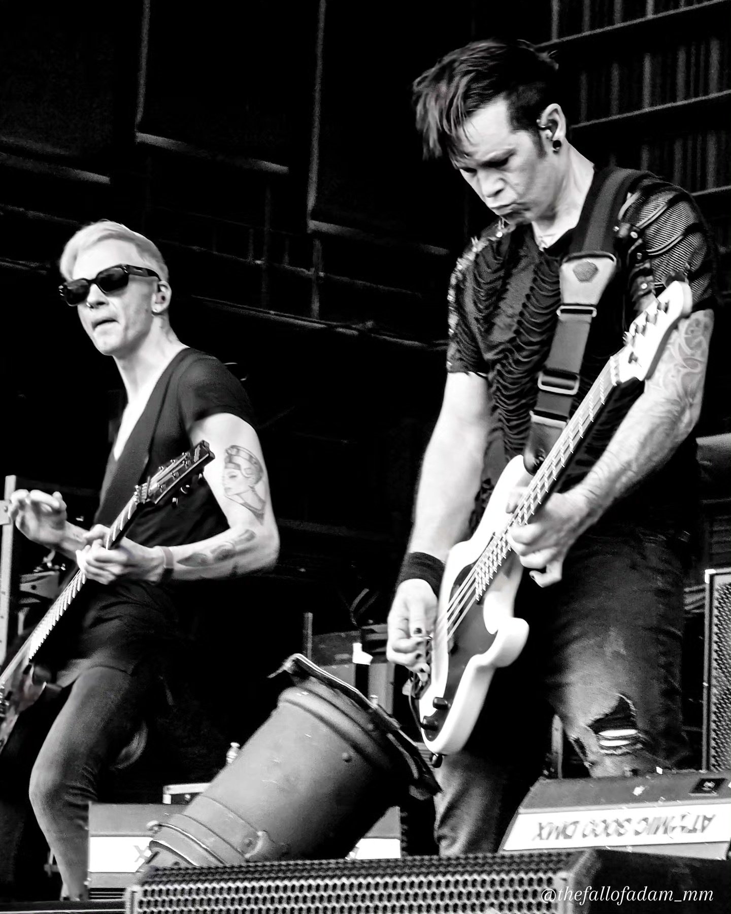 Two Orgy guitarists playing onstage in black and white.