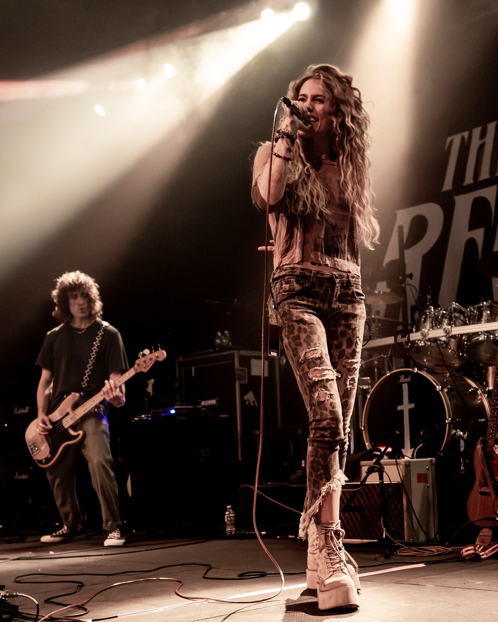 Paris Jackson performing beneath a white spotlight.