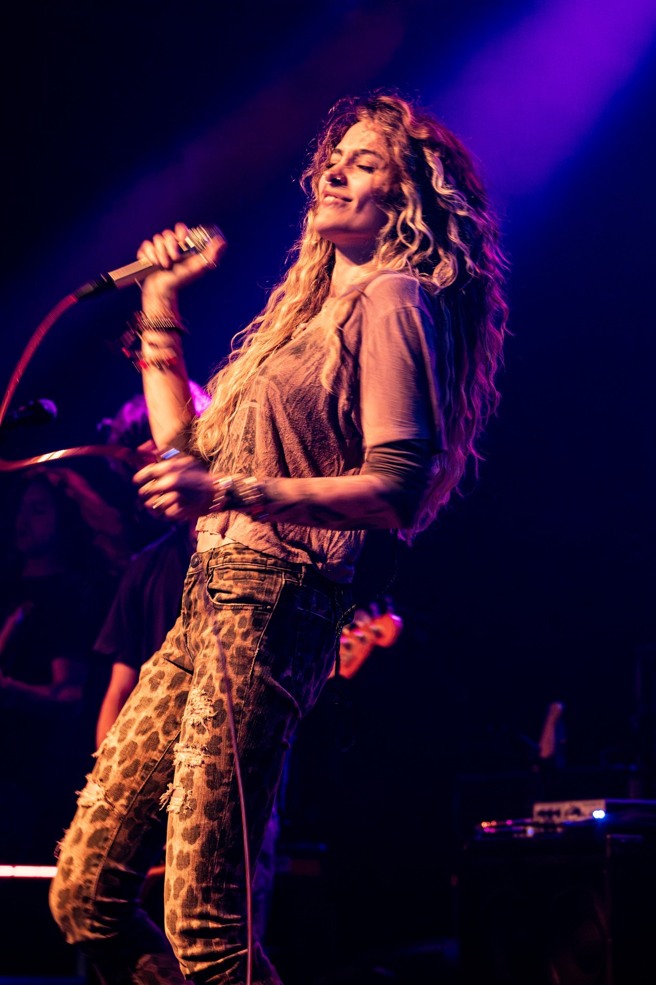 Paris Jackson singing into a handheld microphone.