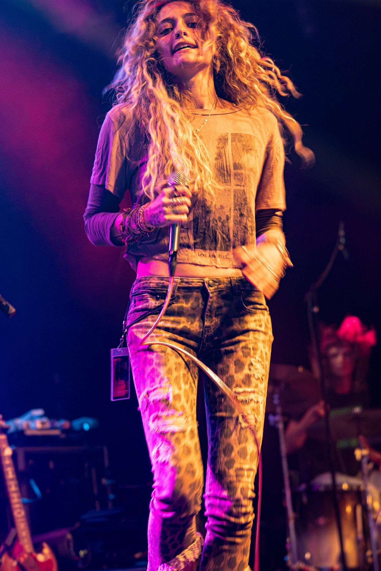 Paris Jackson smiling onstage while holding her microphone.