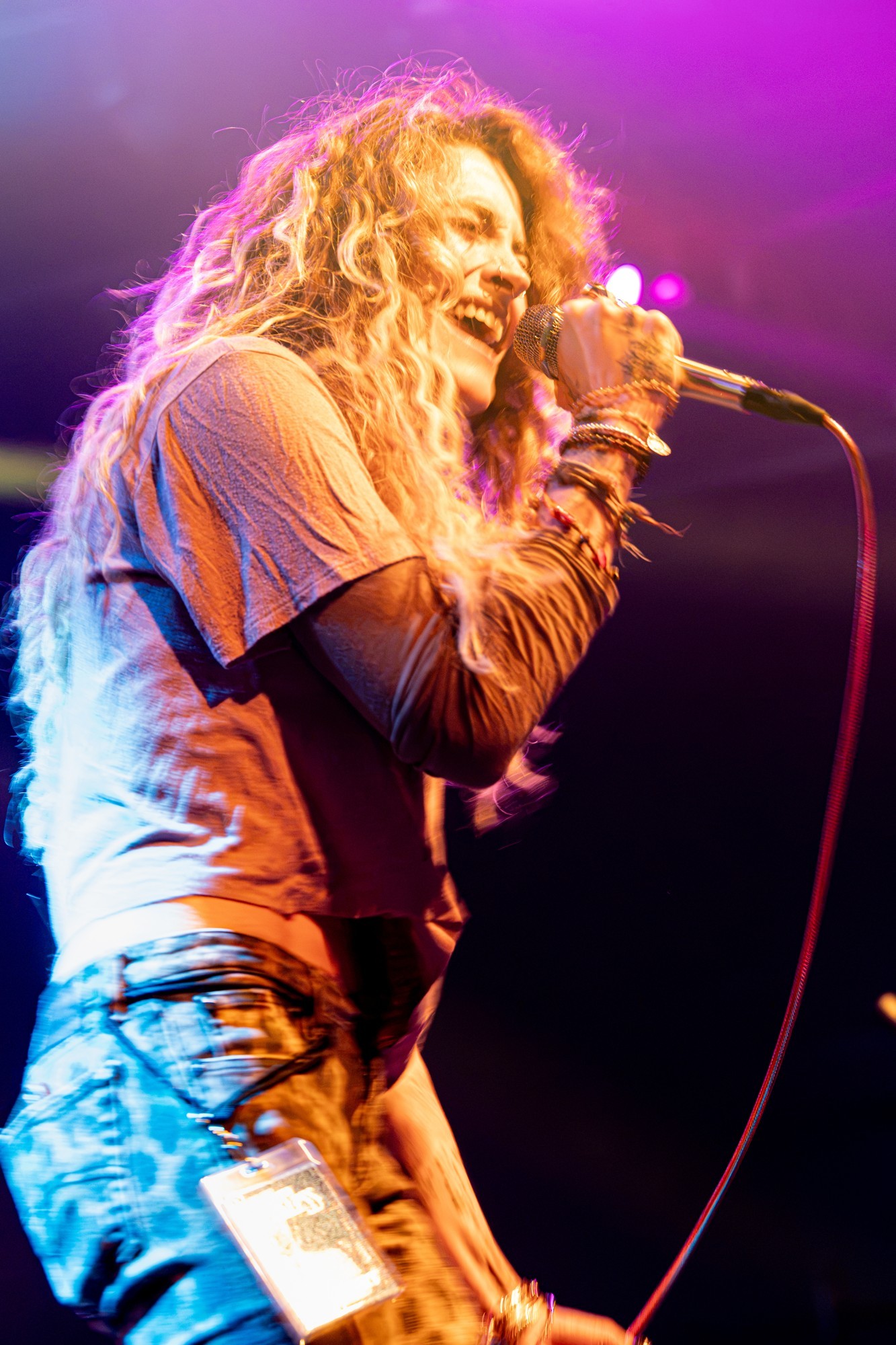 Paris Jackson singing in profile beneath purple lights.