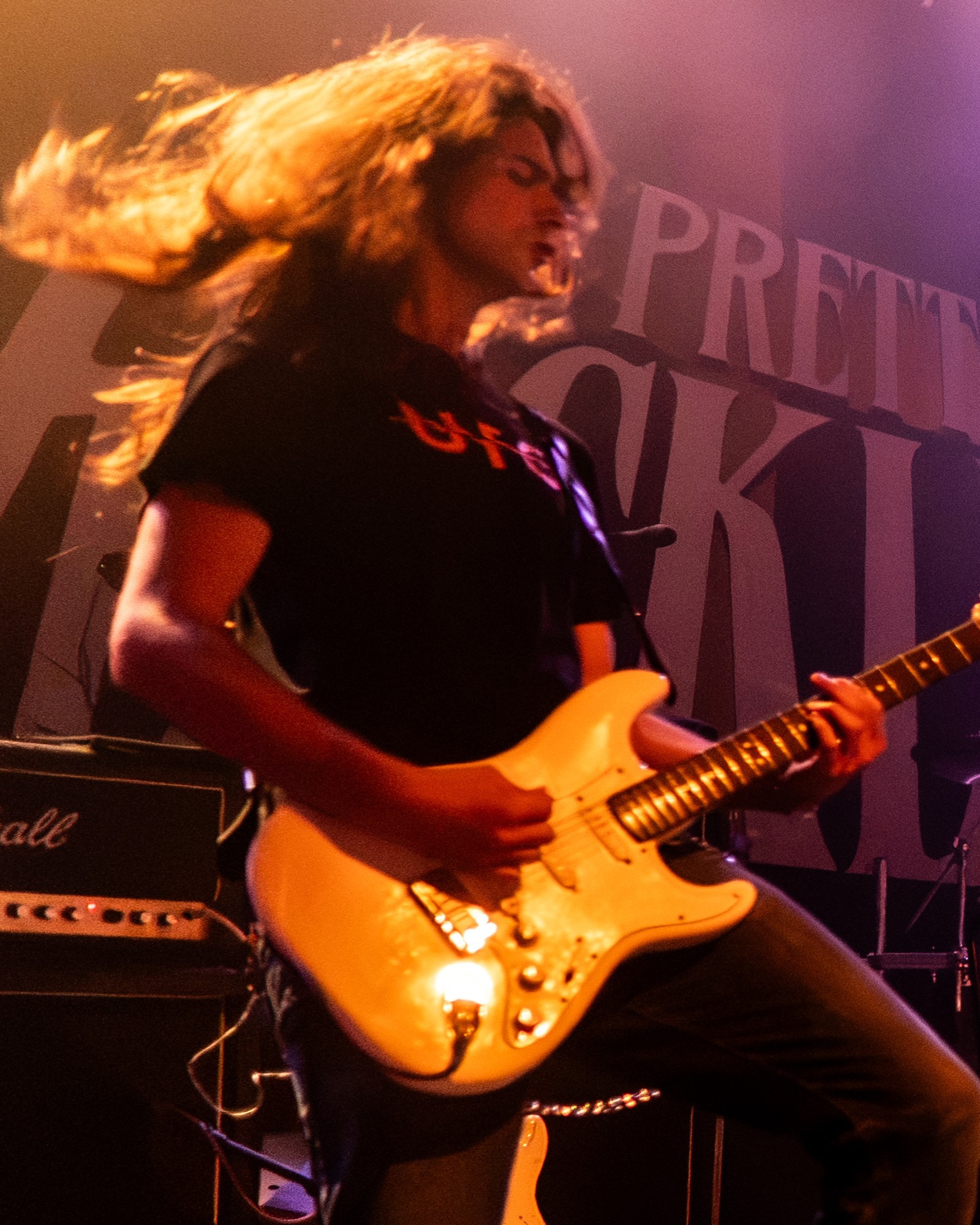 Paris Jackson guitarist performing beneath warm lights.