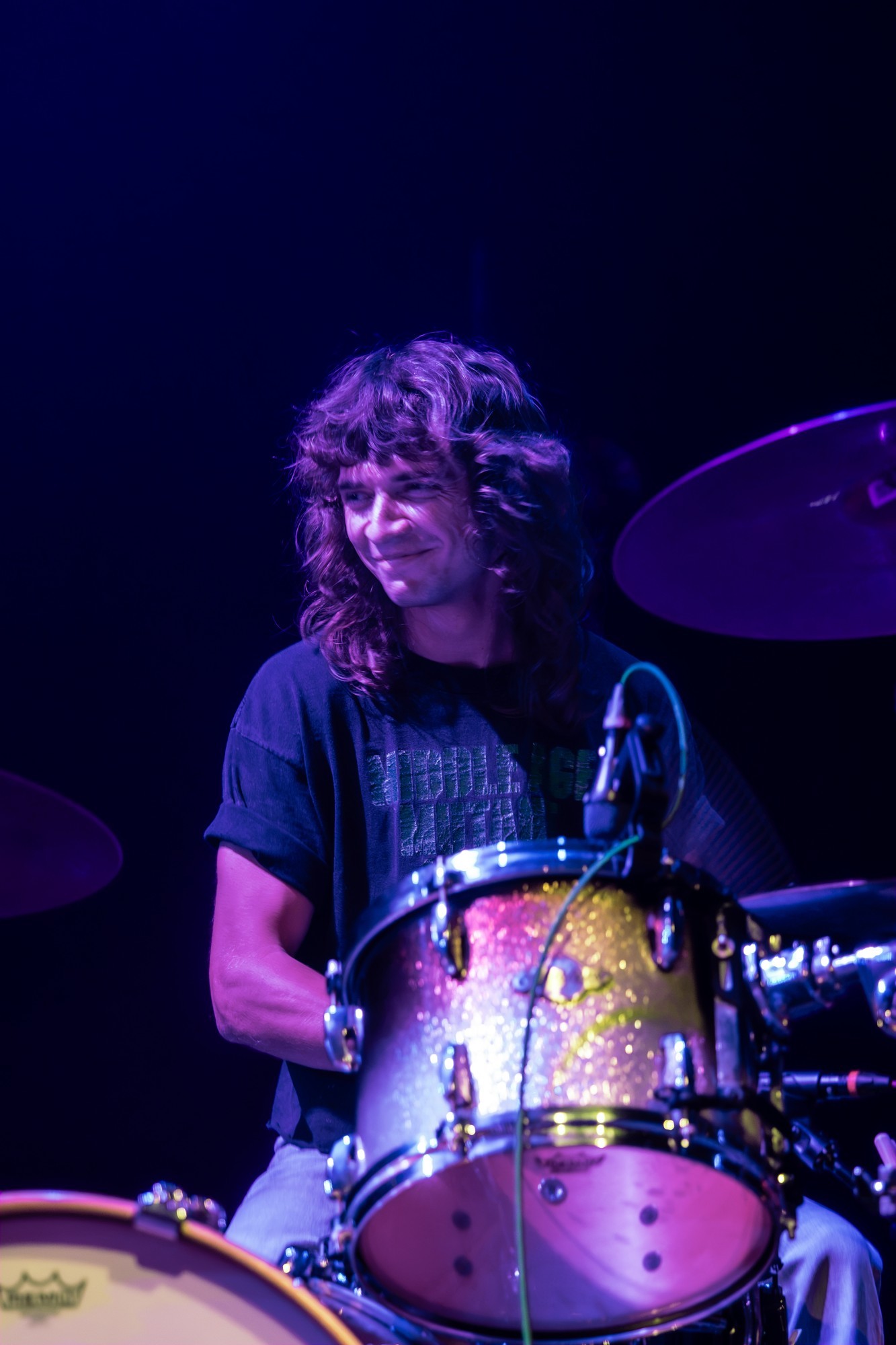 Paris Jackson drummer at his kit beneath purple lights.