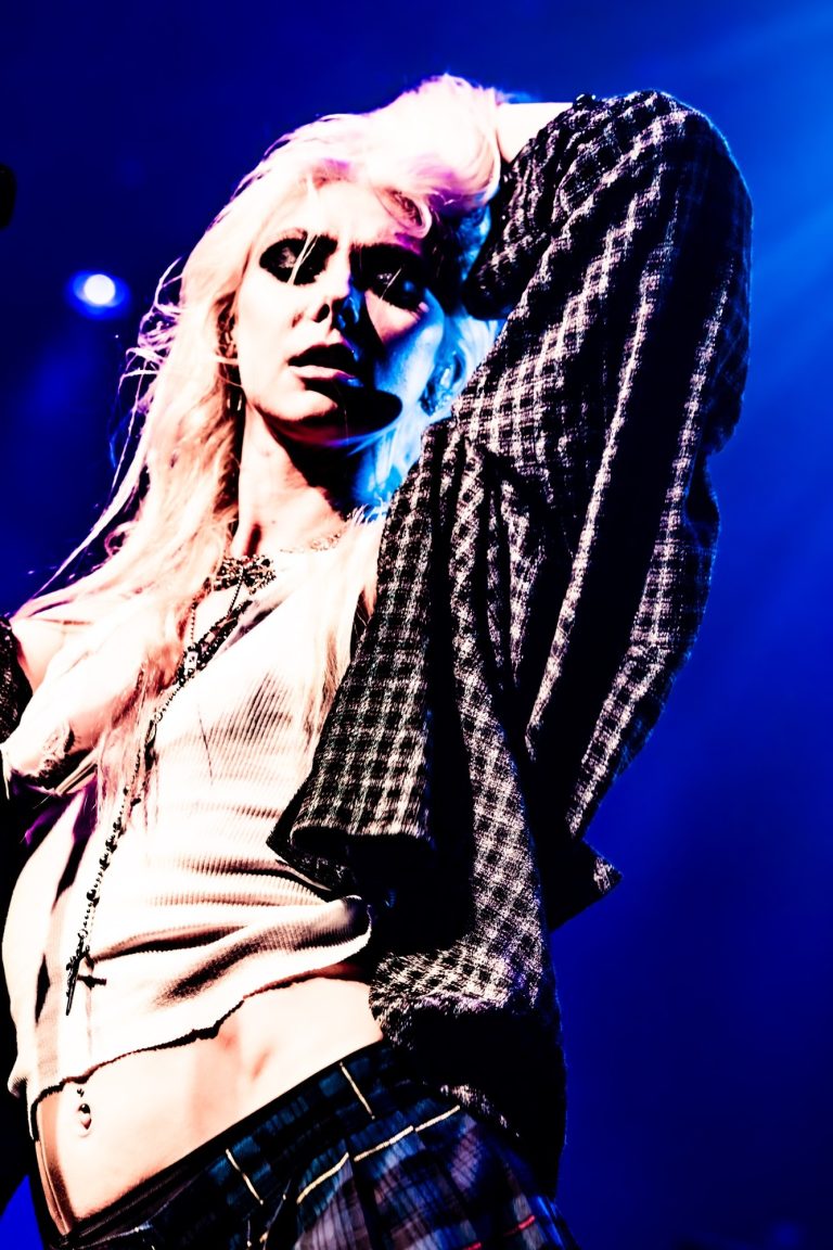 Taylor Momsen posing beneath blue lights during The Pretty Reckless.