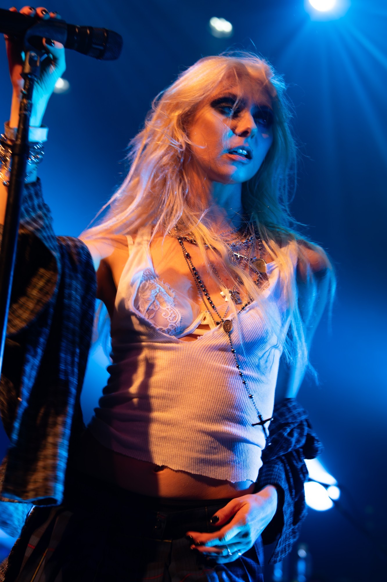 Taylor Momsen looking across the stage beneath blue lights.