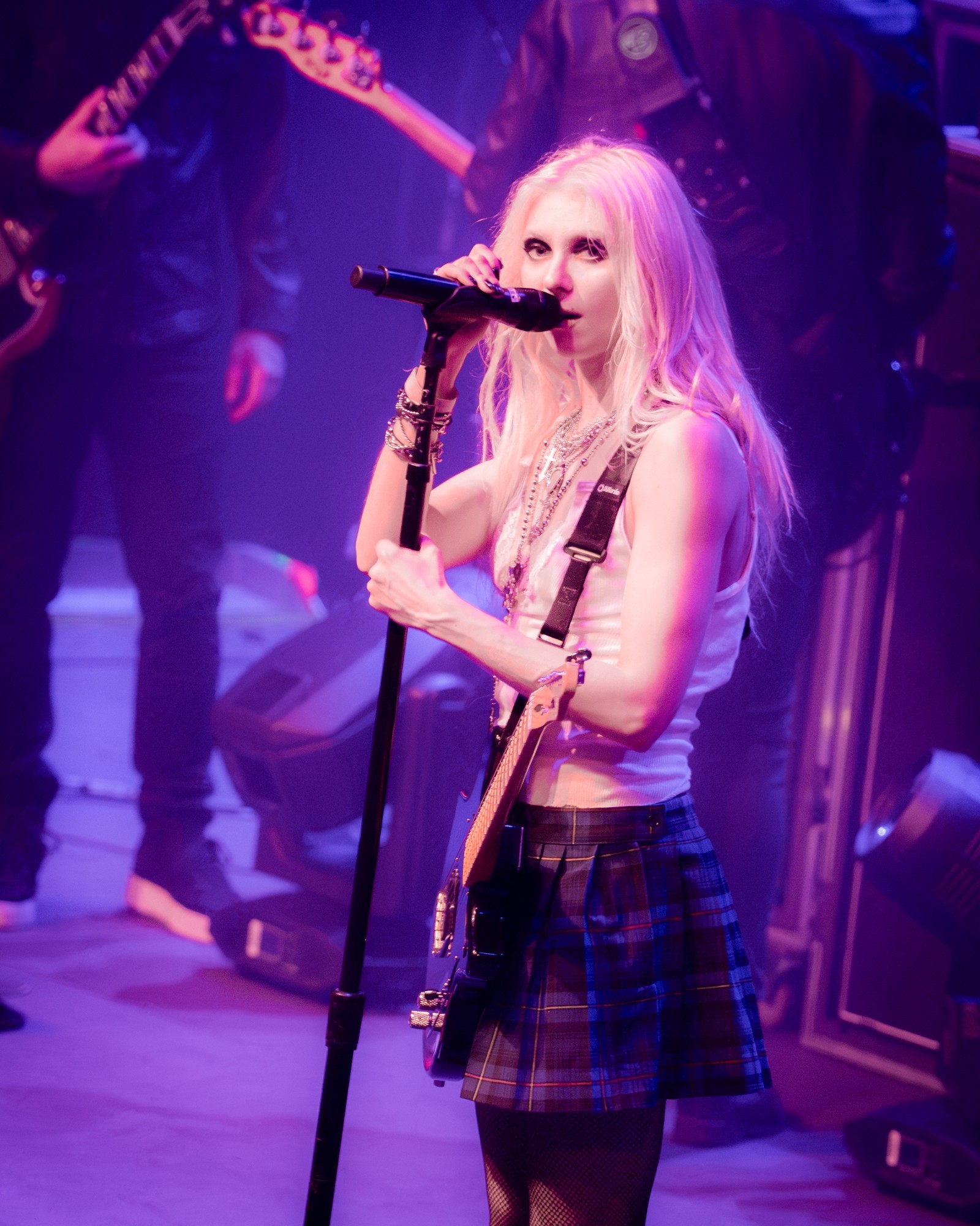 Taylor Momsen singing and raising her arm under purple lights.