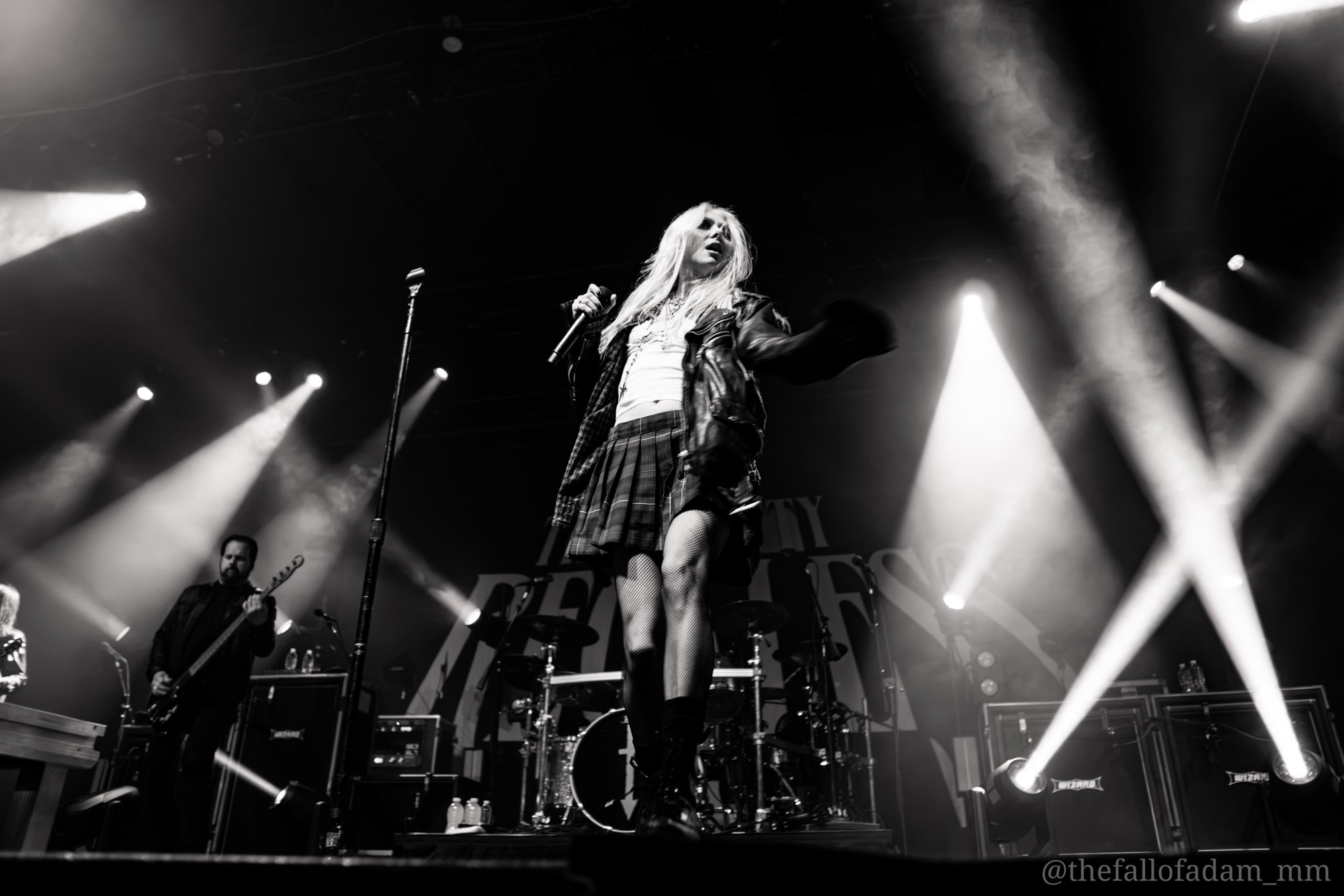 Black and white view of Taylor Momsen and crossing stage lights.