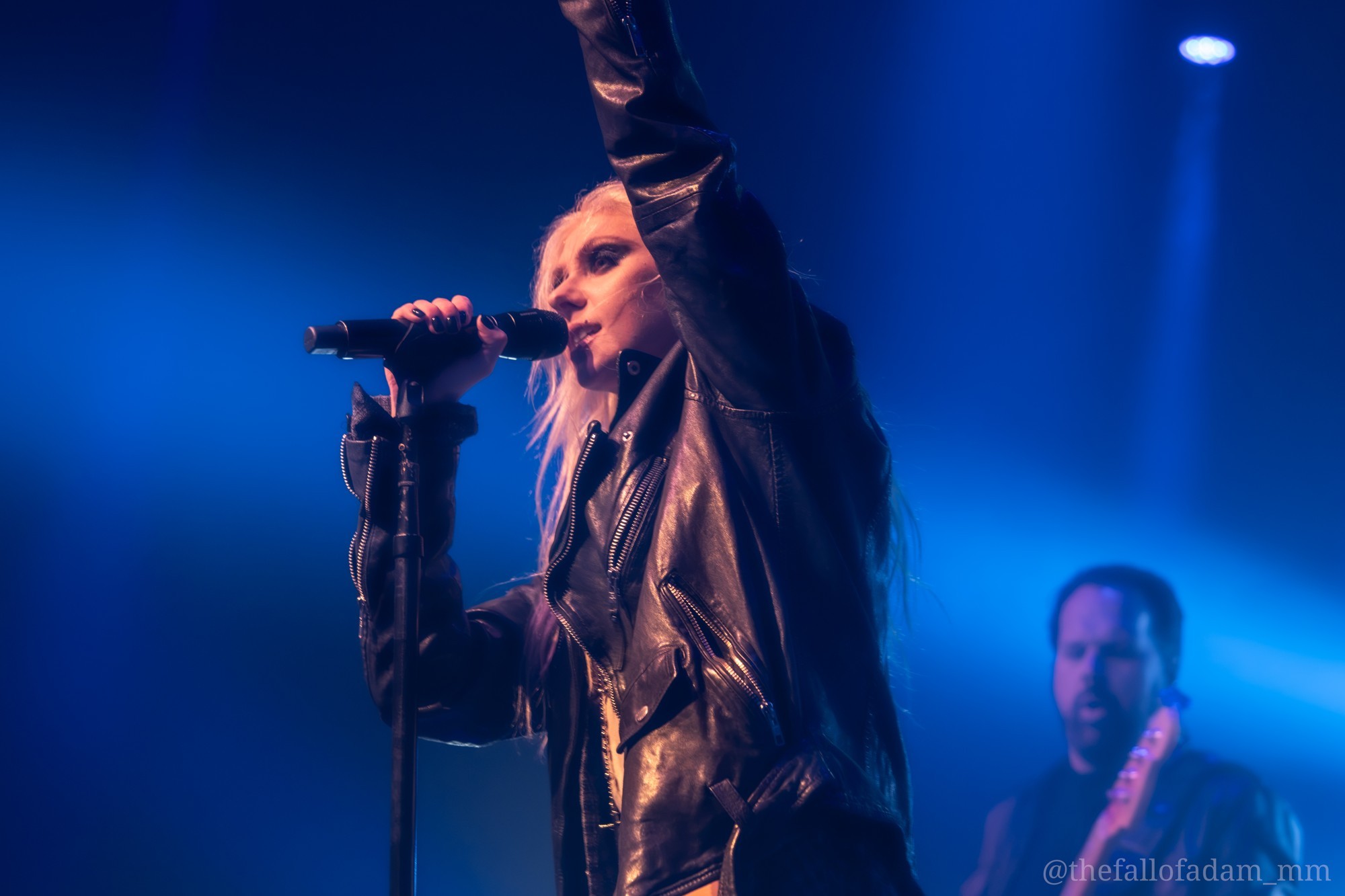 Taylor Momsen reaching upward beneath blue lights.