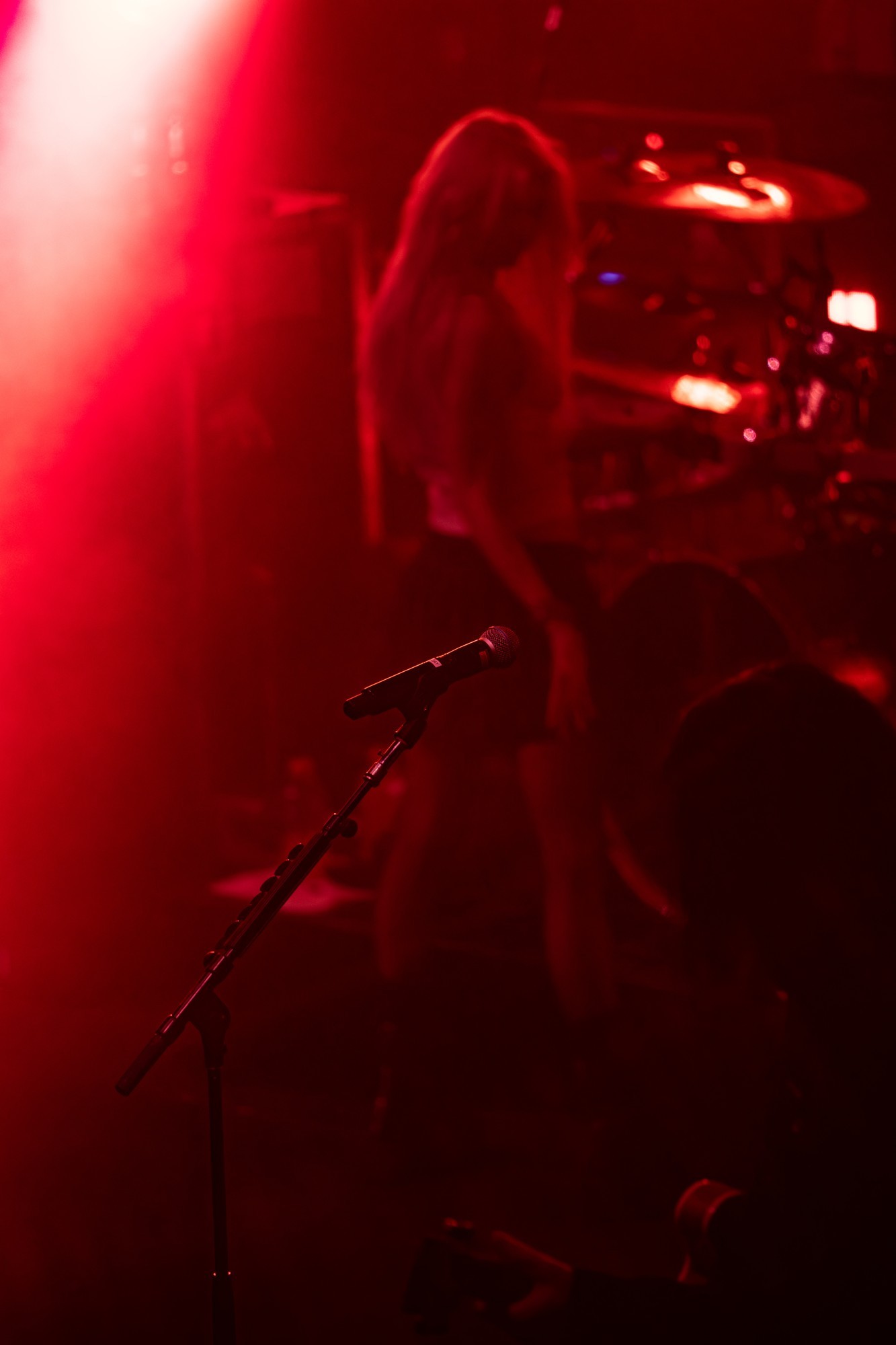 The Pretty Reckless guitarist under red stage lights.