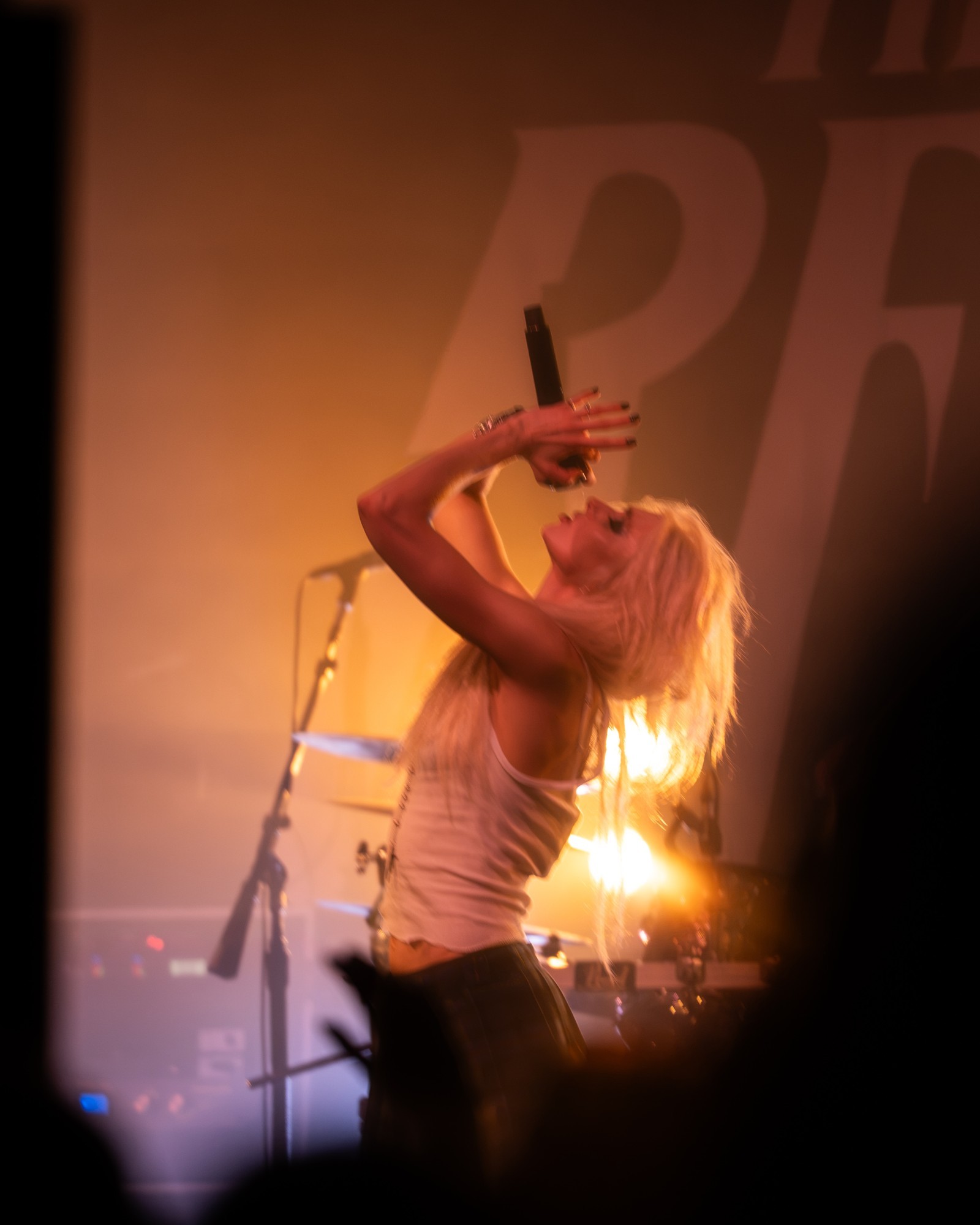 Taylor Momsen silhouetted beneath amber lighting.