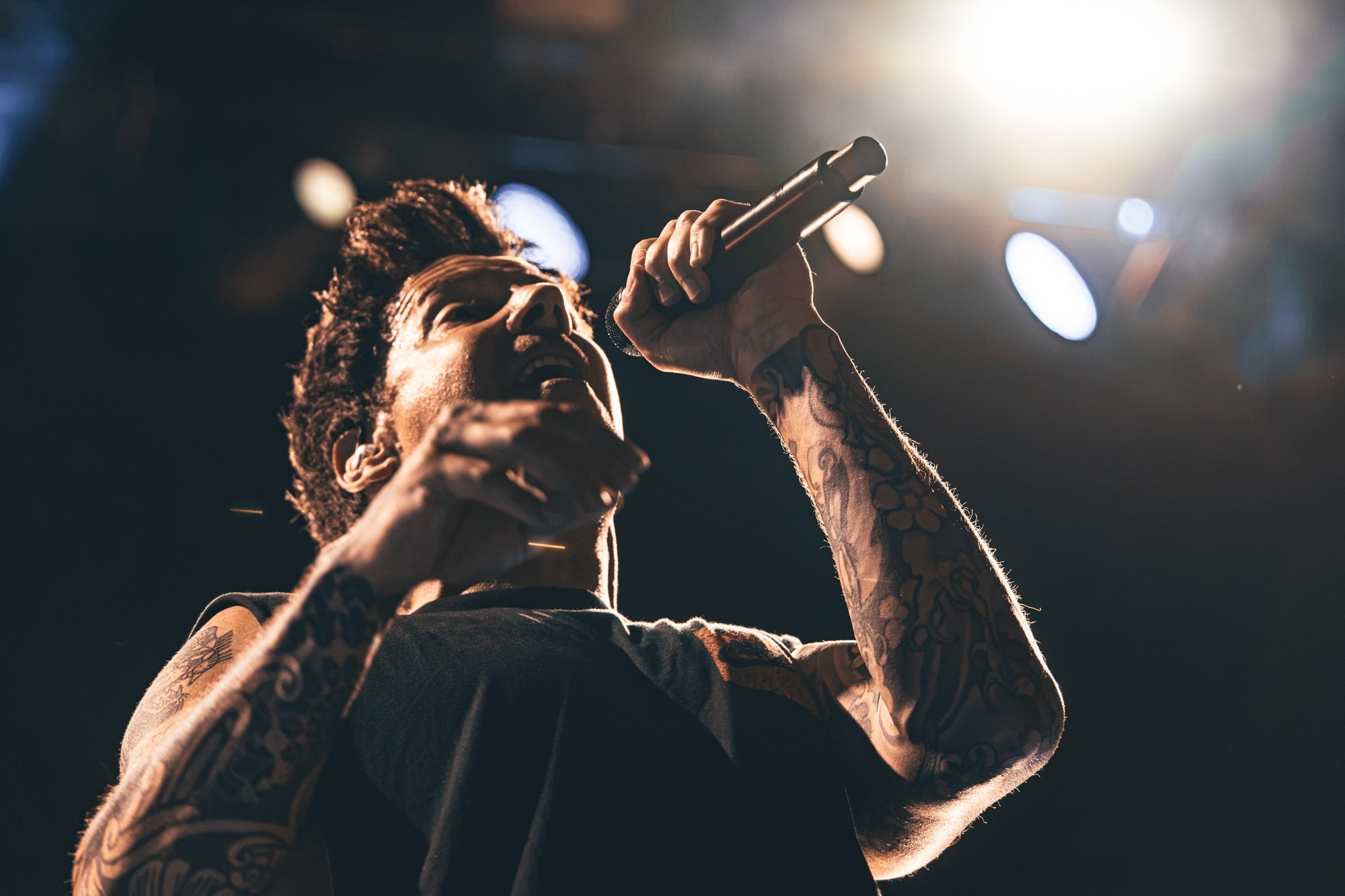 Close view of the Simple Plan vocalist with his microphone.